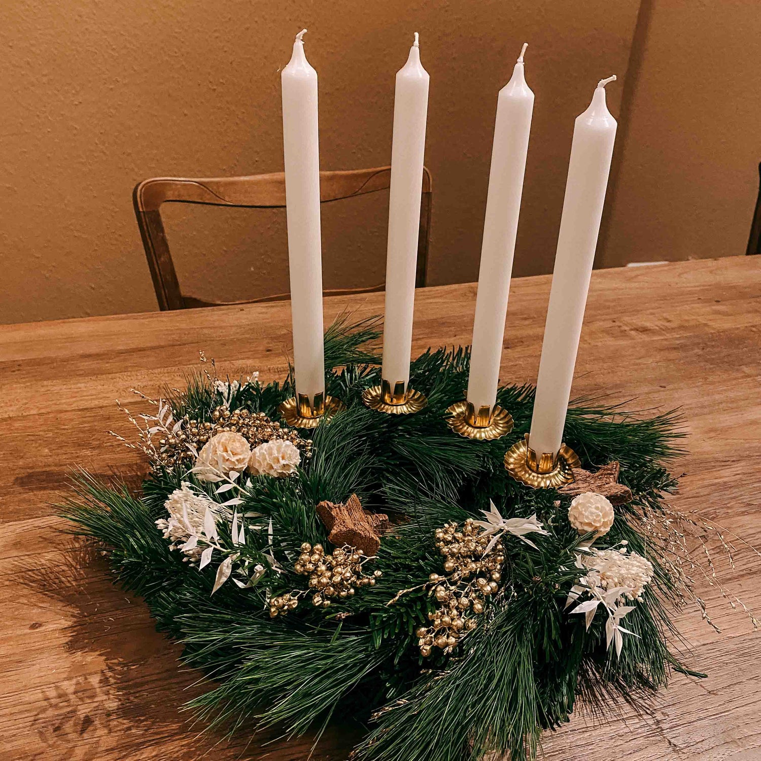 Kranz mit weißen Blumen, goldenen Zweigen und weißen Kerzen – festliche DIY Weihnachtsdeko.
