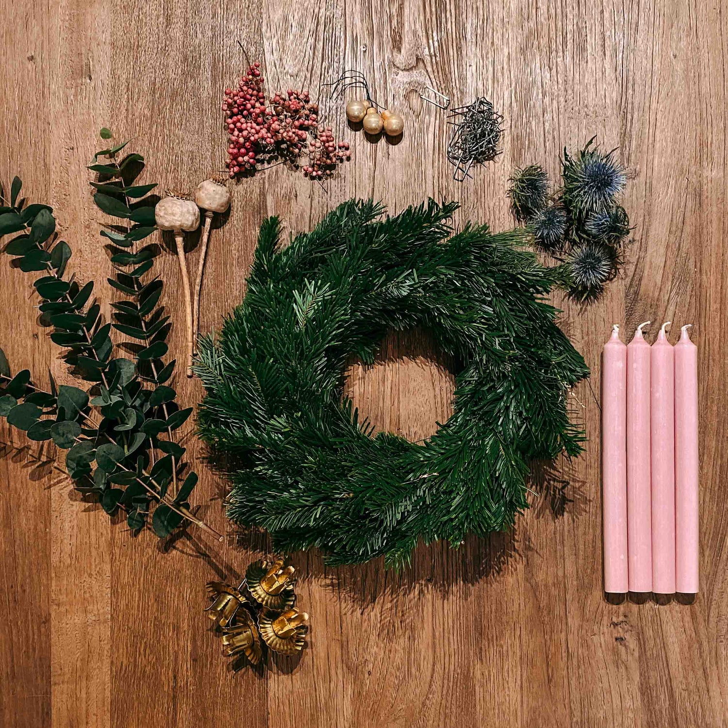 Holztisch mit Materialien aus der DIY Box Aschenputtel – Kerzen, Eukalyptus, Blüten und Kranzrohling