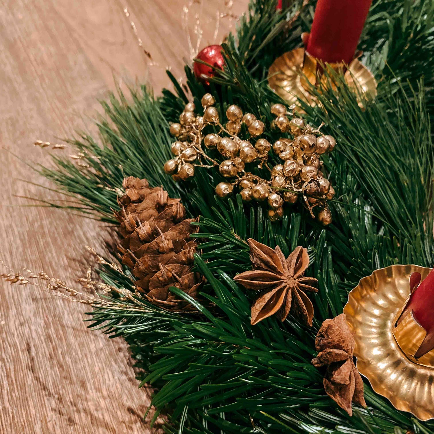 Detailaufnahme mit Anisstern, vergoldeten Beeren und Tannenzweigen – festlicher Kranz Rotkäppchen.