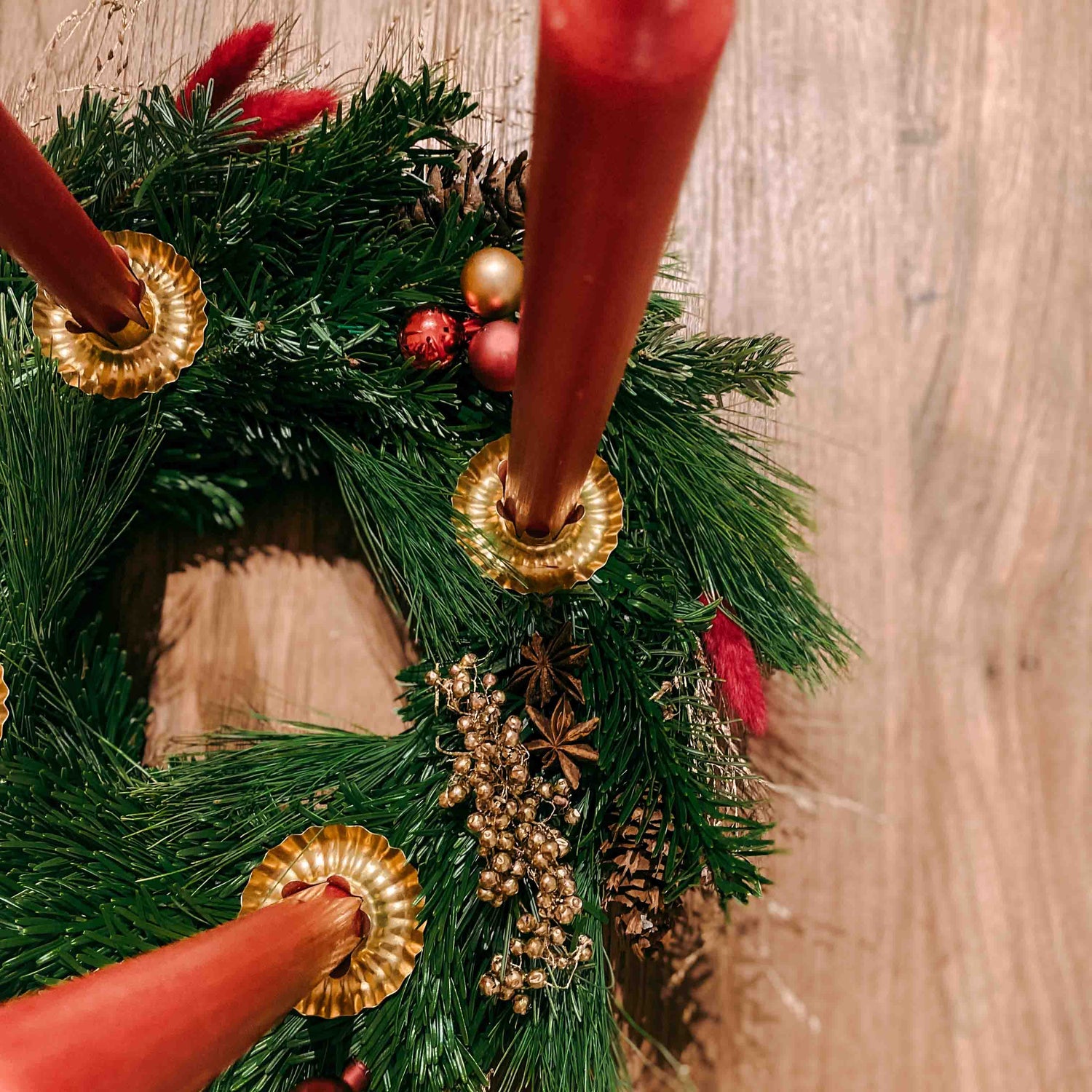Kranz mit goldenen Vogelbeeren und roten Kerzen – elegante Weihnachtsdeko zum Selbermachen.