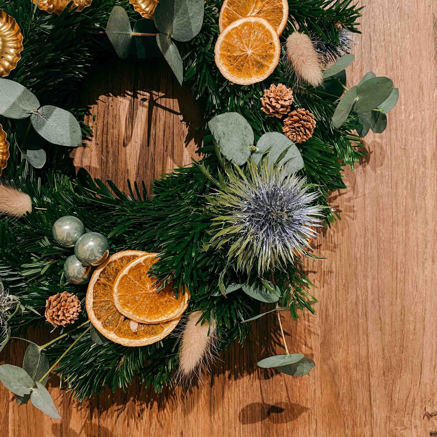 Blaue Blume mit Orangenscheiben und Kugeln – festliche Adventskranz Dekoration Sterntaler.