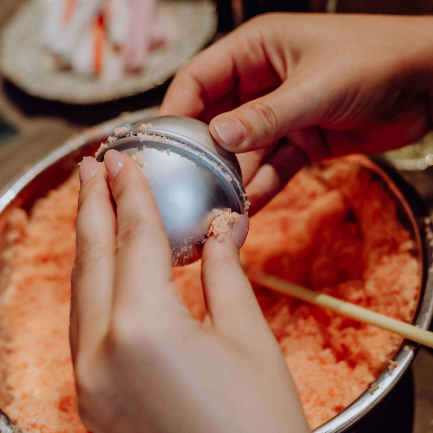 Badekugel wird von zwei Händen zusammengedrückt – Badekugel, Badebombe, DIY Badekugel.