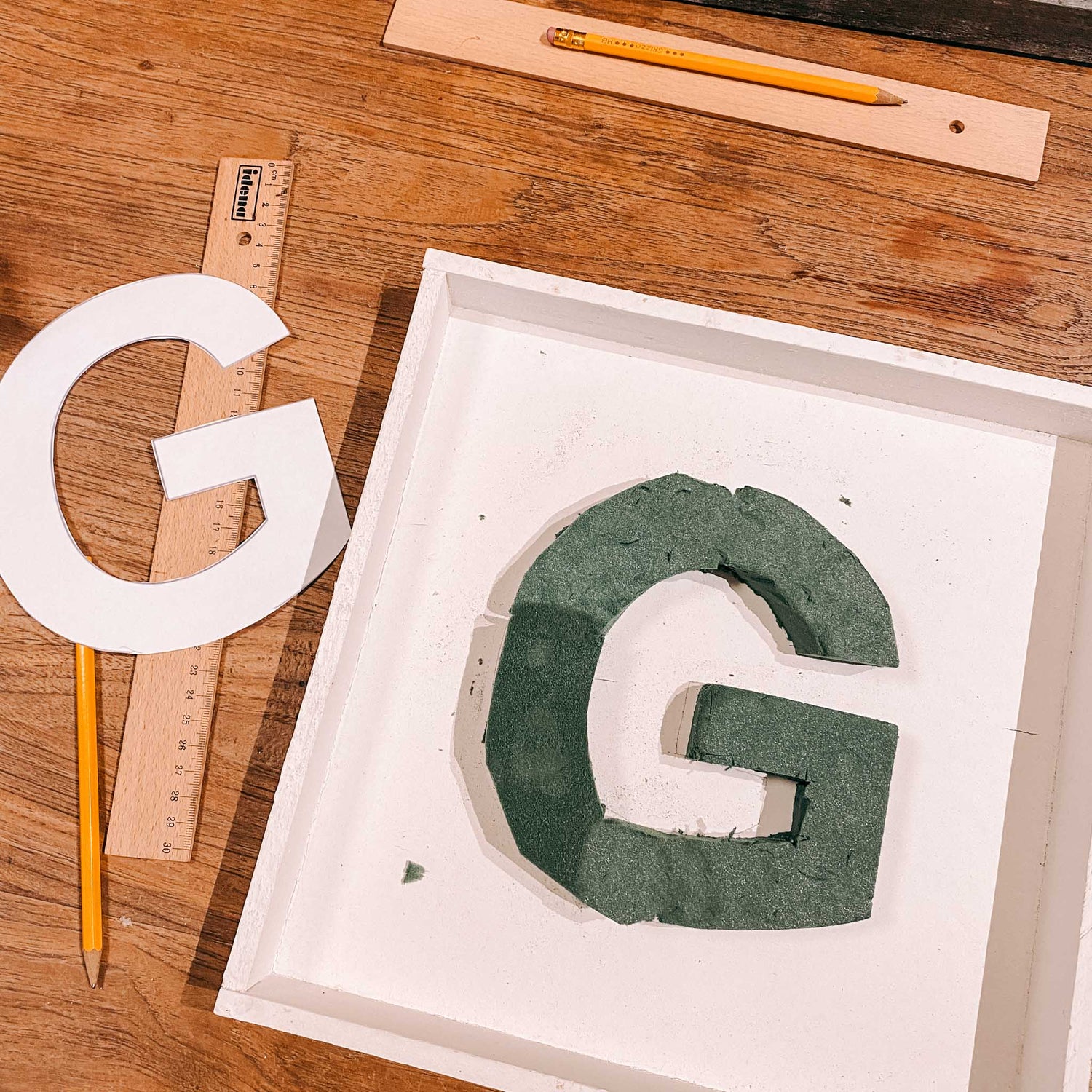 Ausgeschnittenes G im weißen Rahmen mit Lineal – blumenmonogramm workshop, floral letter basteln.