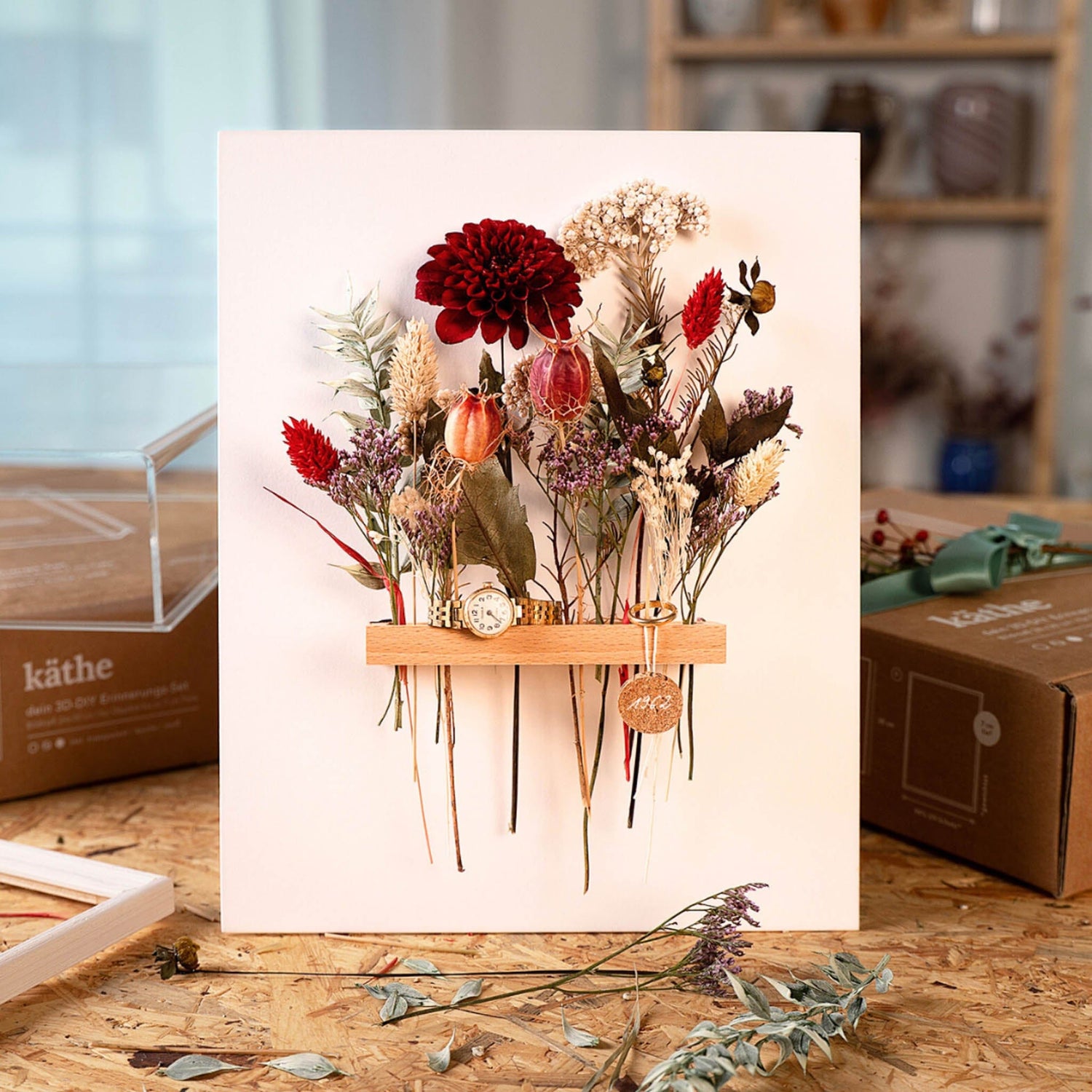 Verschiedene Farben und Blumen im Rahmen, goldene Uhr im Inneren – trockenblumen kunstwerk workshop.