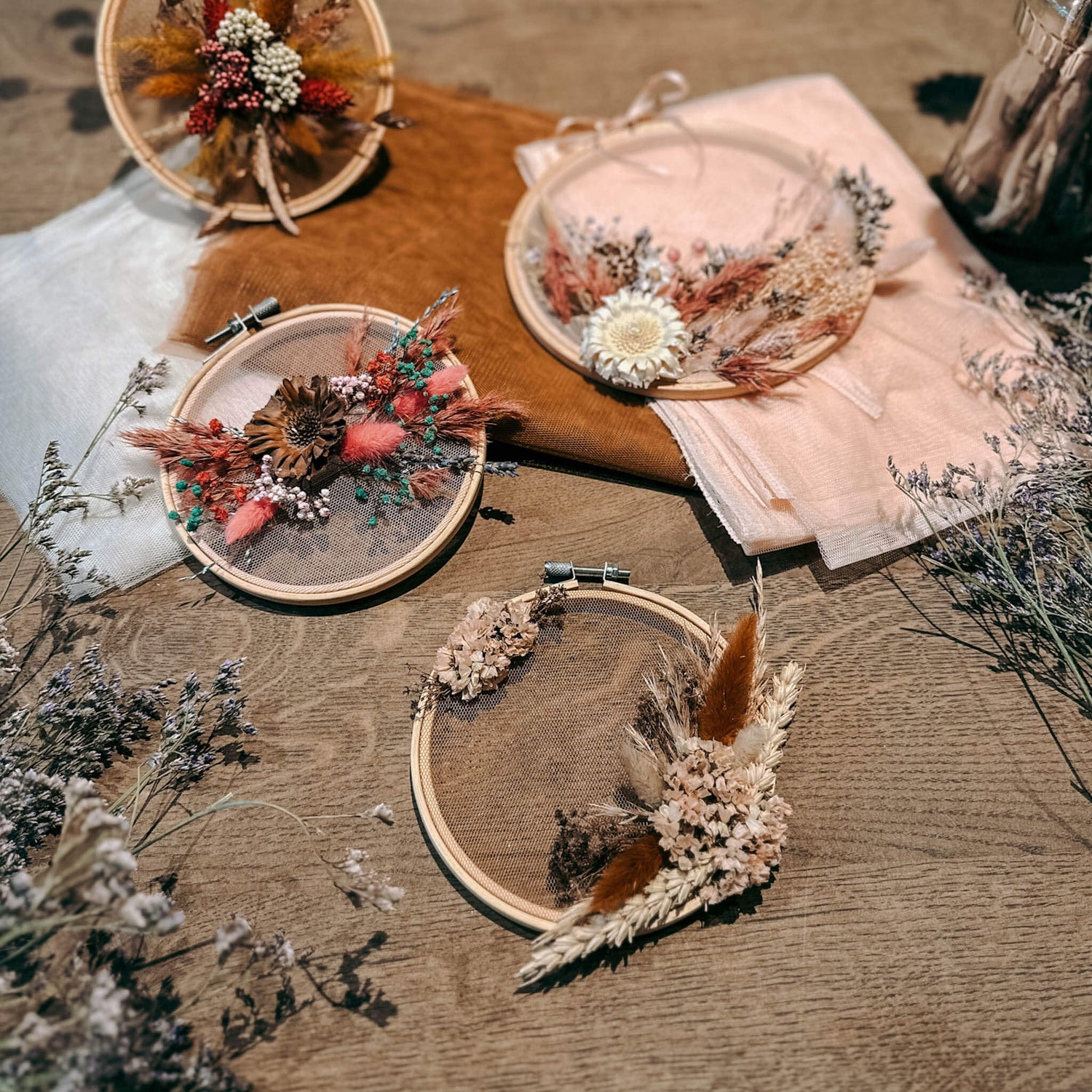 Vier fertige Blumenwandbilder in verschiedenen Farben auf Holztisch – DIY Blumenbild, Trockenblumen Wandbild