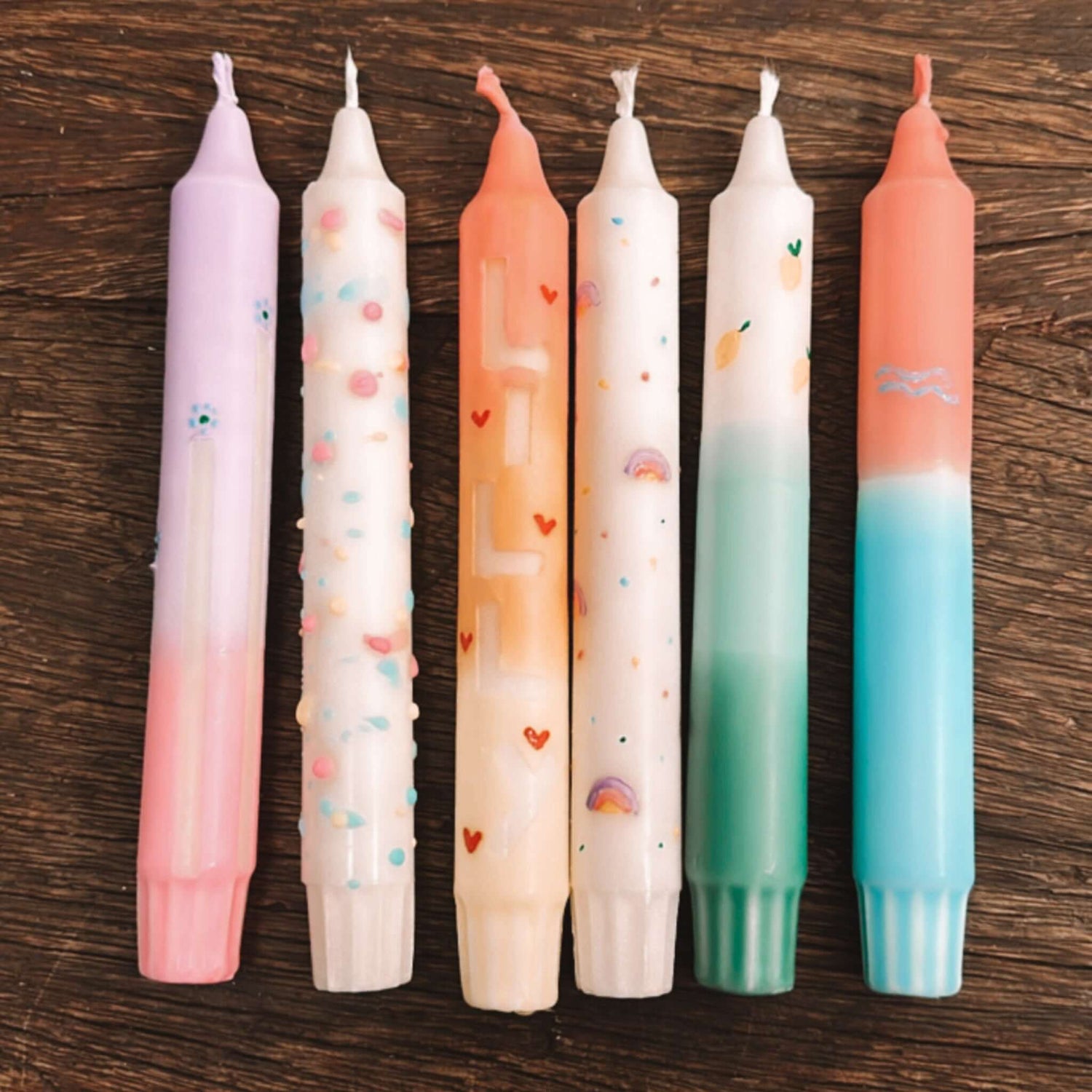 Mehrere bunte Kerzen zusammen auf Tisch arrangiert – kerzenset selber machen, dip dye kerzen.Auch als Firmenevent buchbar.