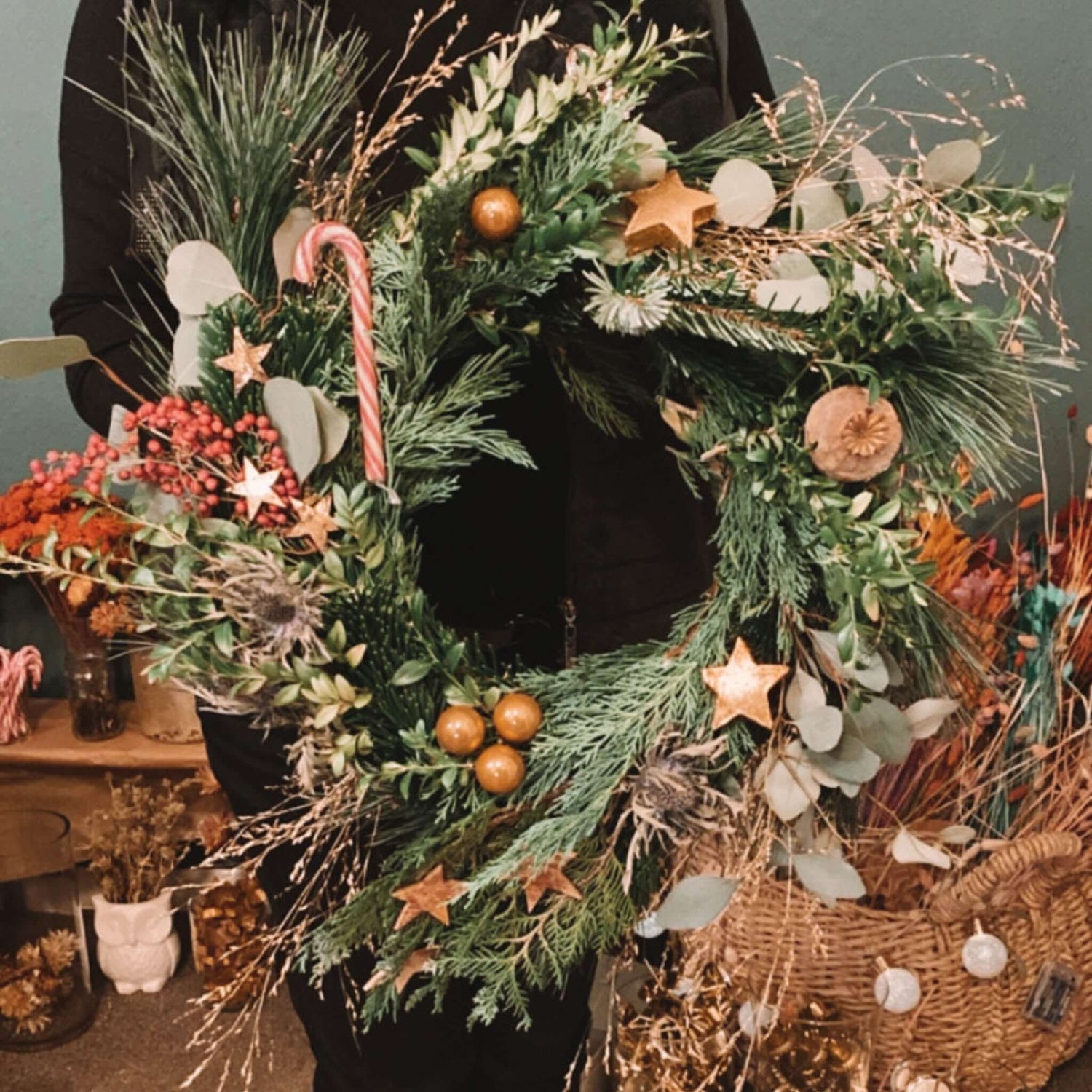 Stimmungsvolles Detailfoto eines adventskranz modern mit Zuckerstange und Stern.Auch als Firmenevent buchbar.