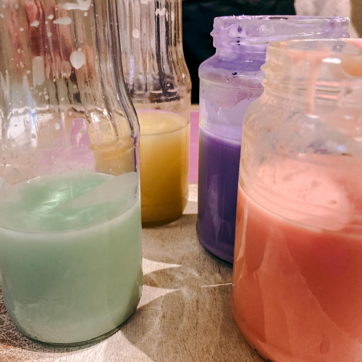 Buntes Wachs in verschiedenen Gläsern auf Tisch – kerzen dekorieren, dip dye kerzen.Auch als Firmenevent buchbar.