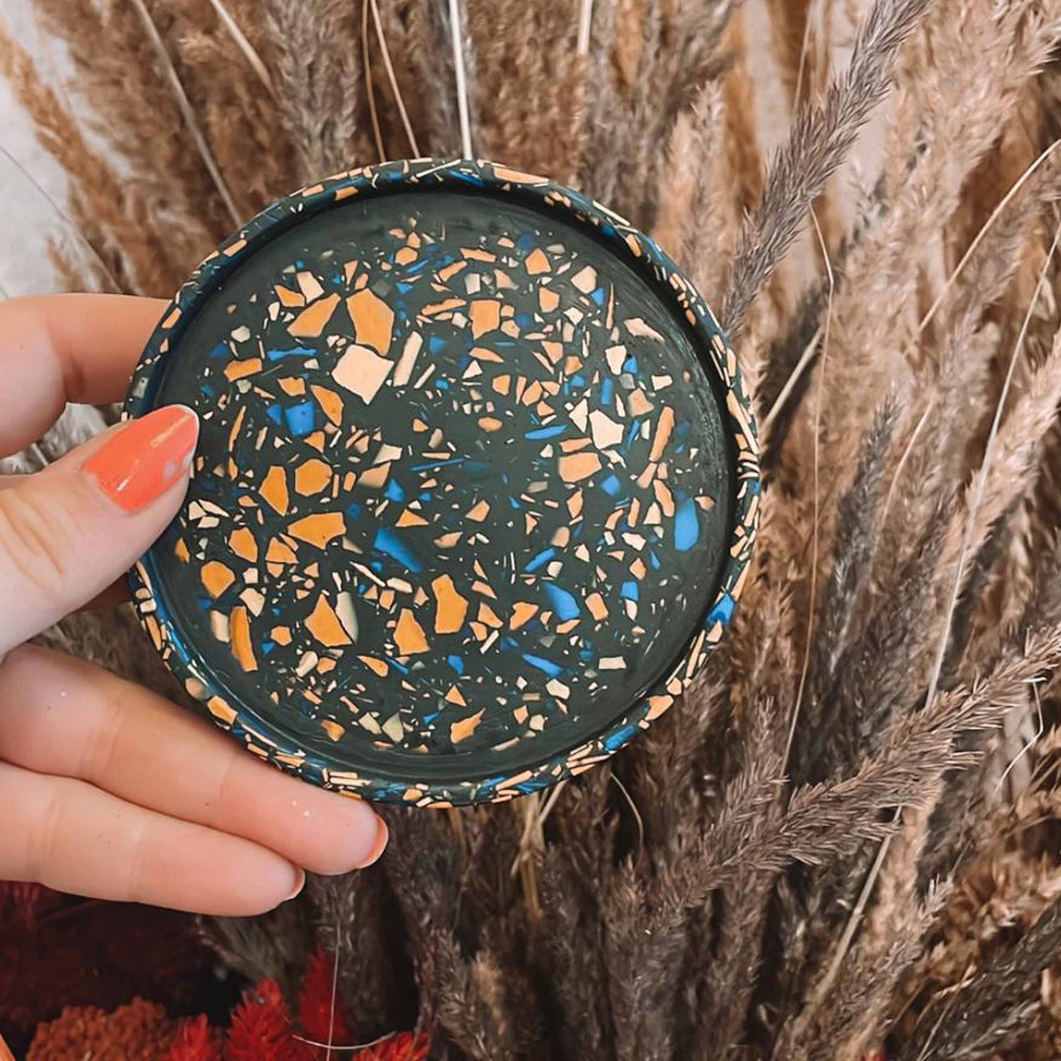 Schwarzer Terrazzo-Untersetzer mit bunten Chips – nachhaltige DIY Deko im Terrazzo Workshop.