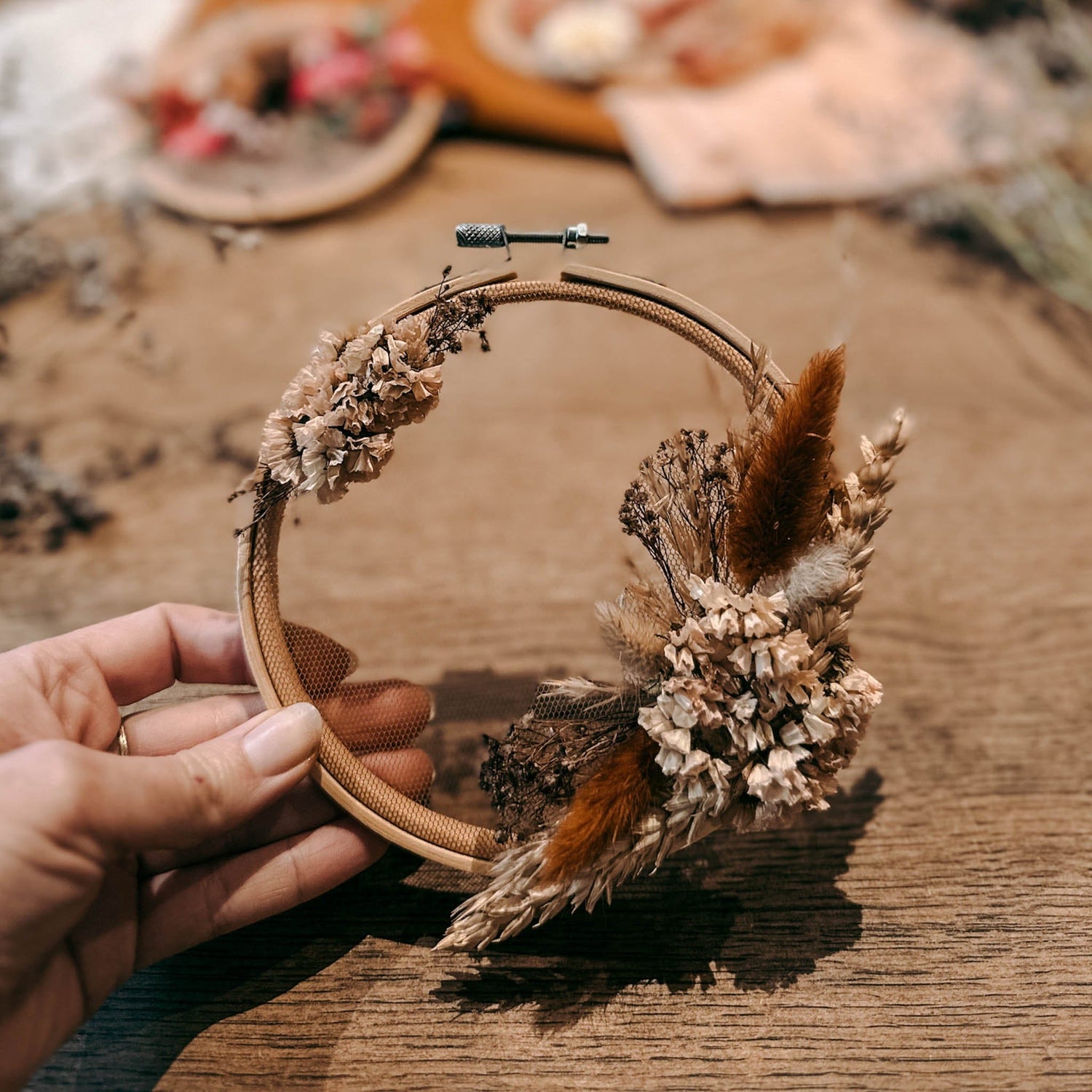 Hand hält fertigen Trockenblumenring mit beigen und orangenen Blumen – DIY Blumenring, Trockenblumen Workshop