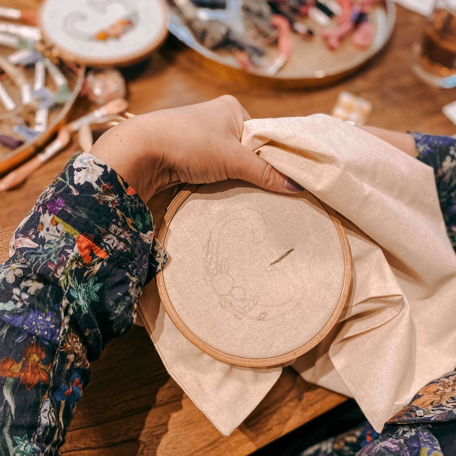 Hand hält Stickrahmen mit aufgemaltem Buchstaben – Stickkurs Berlin, Monogramm Workshop