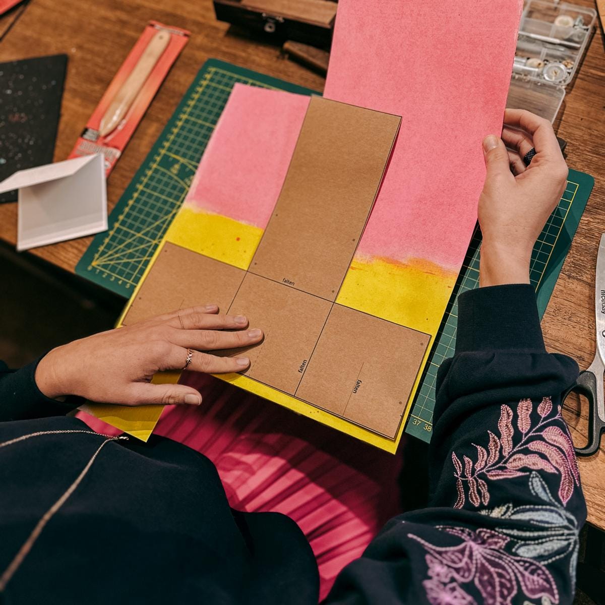 Vorlage für Wallets auf ausgebreitetem gelbem und rosa veganem Leder, kreativer DIY Workshop bei Grimms Garten Berlin