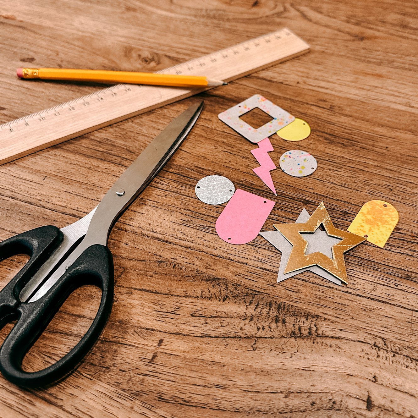 Holztisch mit ausgeschnittenen Ohrringformen, Schere und Lineal – veganes Leder Schmuck Workshop