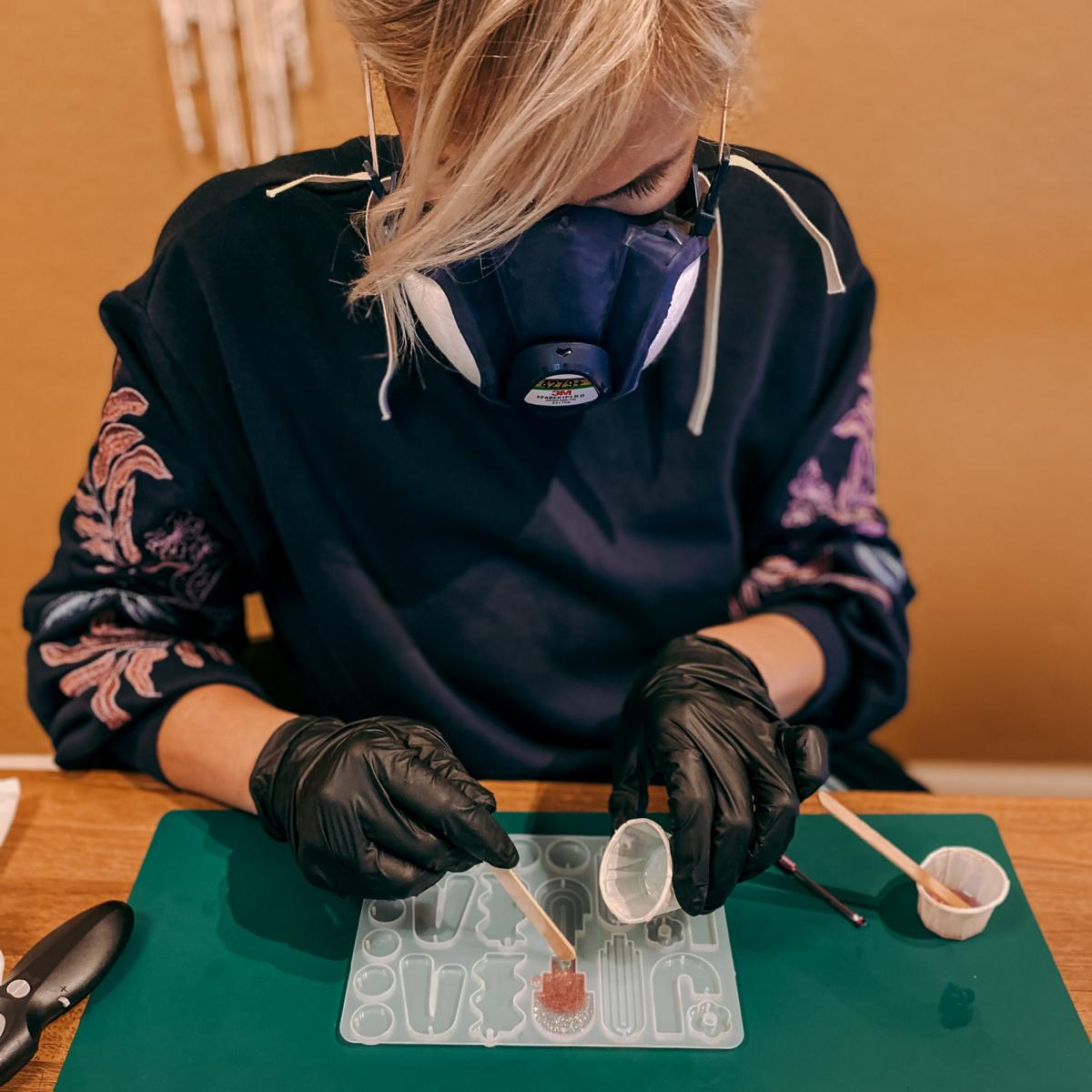 Frau befüllt Resin Gussformen mit Farbe – Schmuckworkshop für individuelle Epoxidharz Ohrringe.