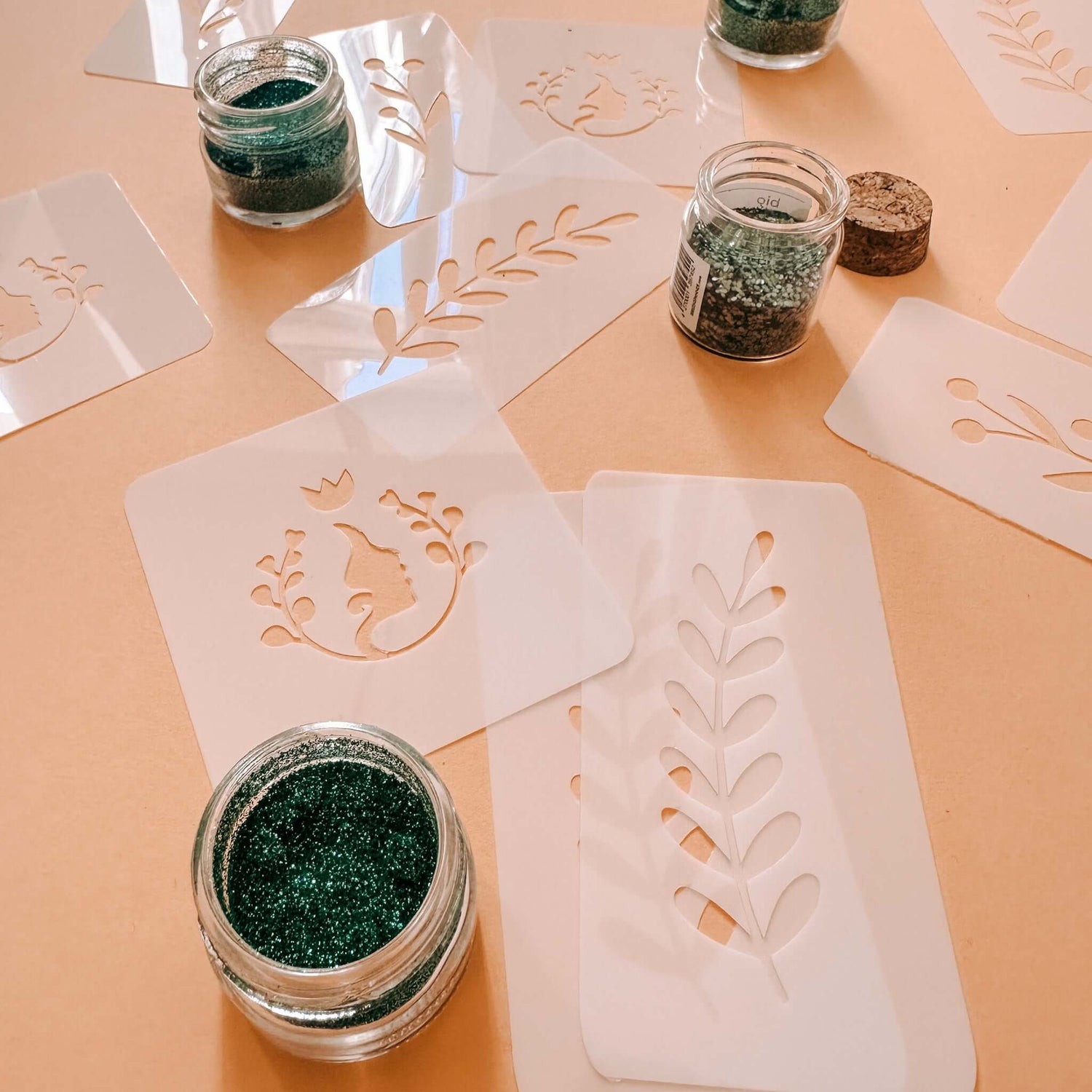 Verschiedene Schablonen mit Glitzerfarben auf Tisch – Bio-Glitzertattoos für Teamevent.