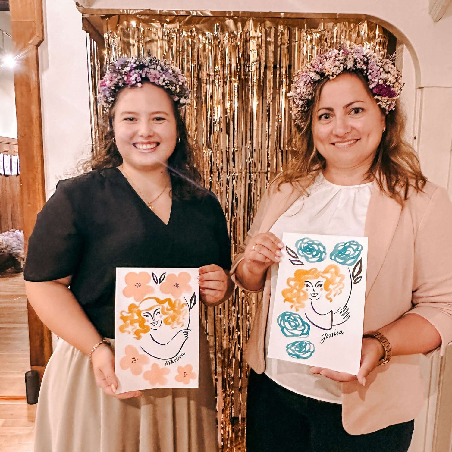 Zwei Frauen halten ihre fertigen Aquarell-Portraits hoch – Schnellportrait Teamevent oder Firmenevent.