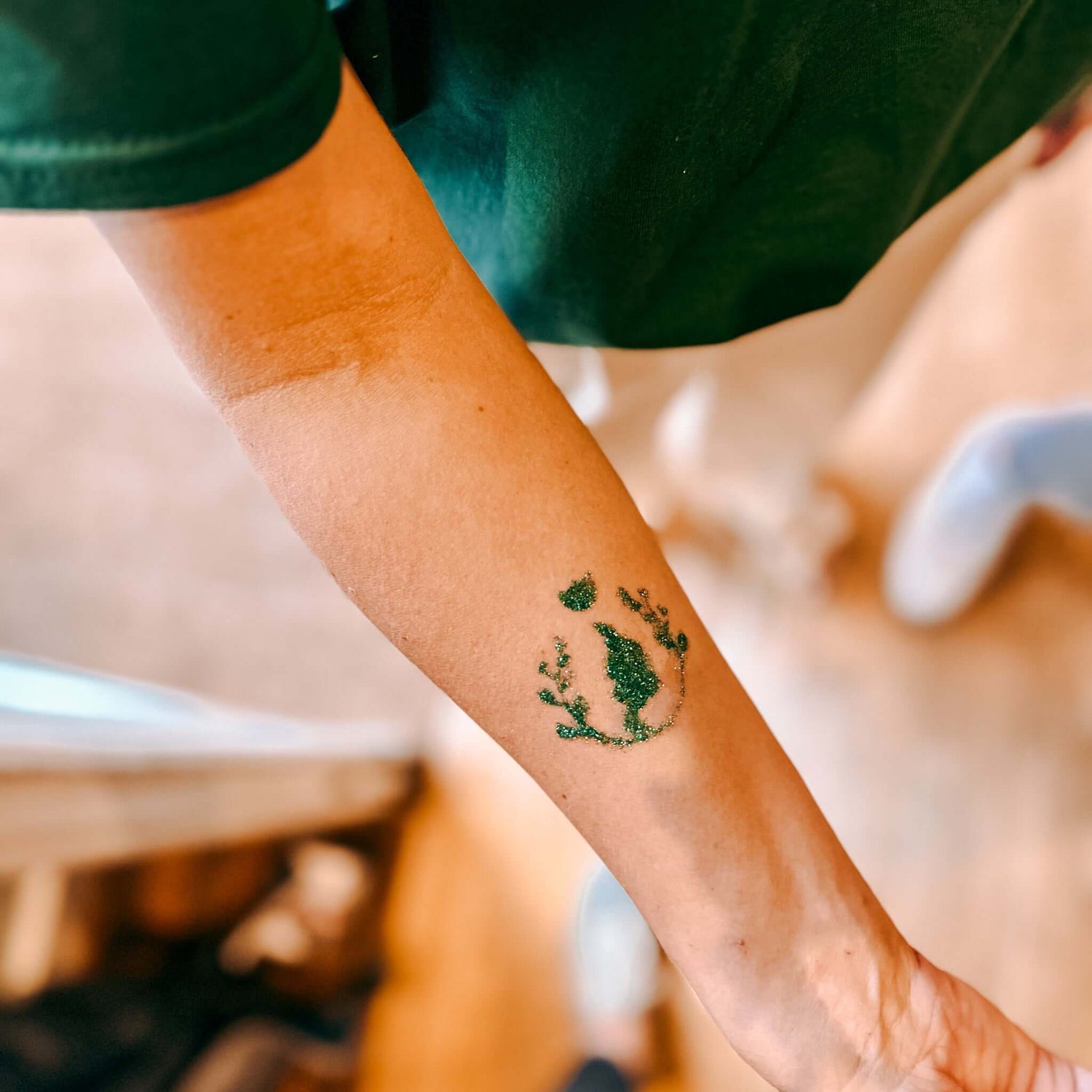Arm mit grünem Bio-Glitzertattoo – Teamevent, Firmenevent oder JGA funkelnde Motive gestalten.