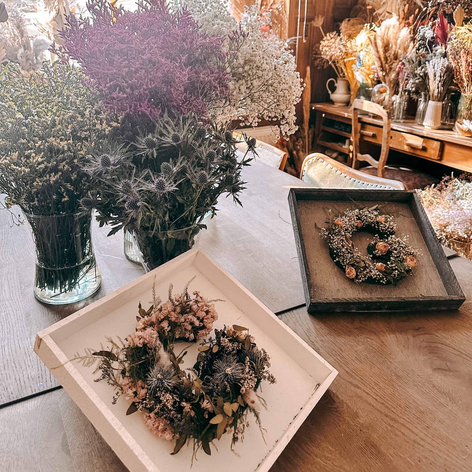 Zwei fertige Blumenbuchstaben auf Holztisch – blumenletter deko, handmade flower monogramm.