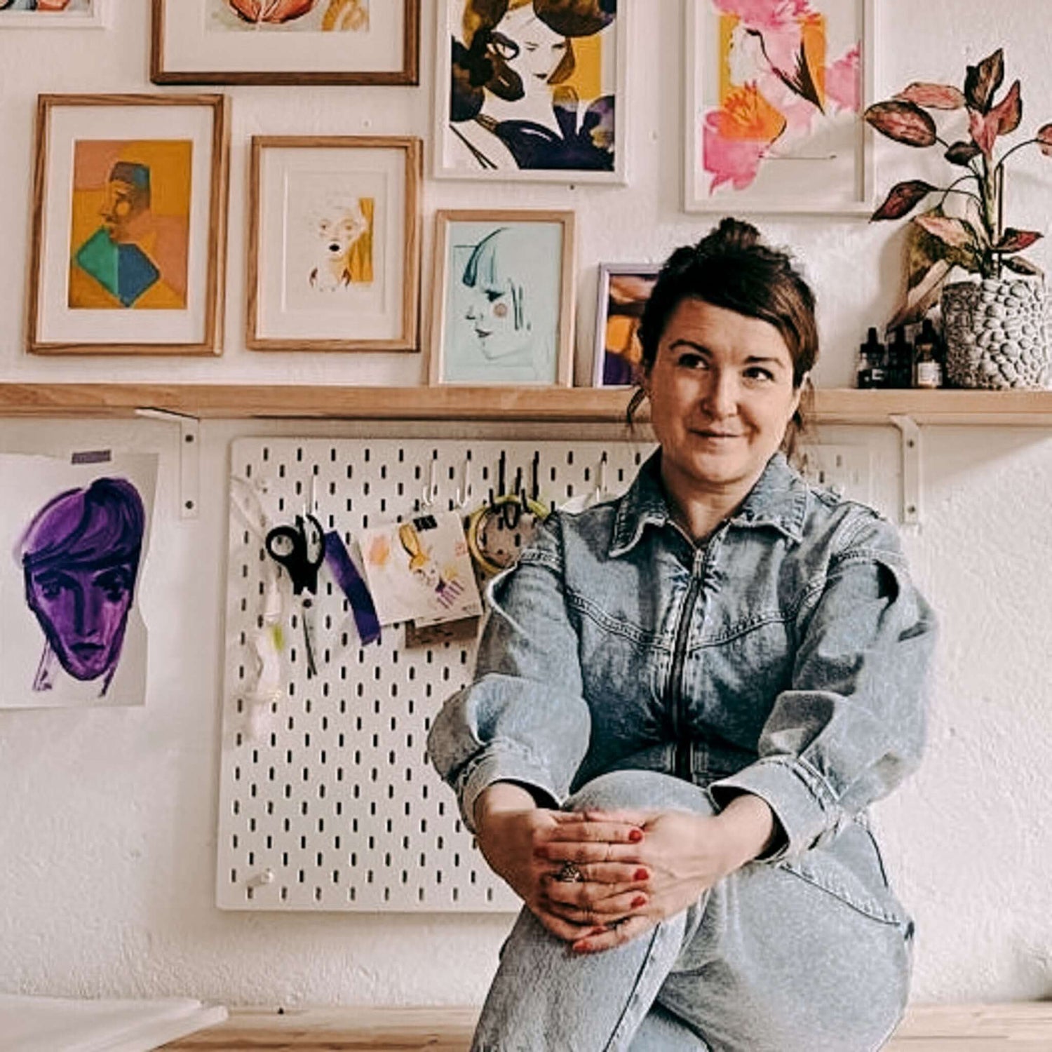 Frau sitzt vor abstrakten Portraits auf dem Tisch, kreativer Kunstworkshop bei Grimms Garten Berlin