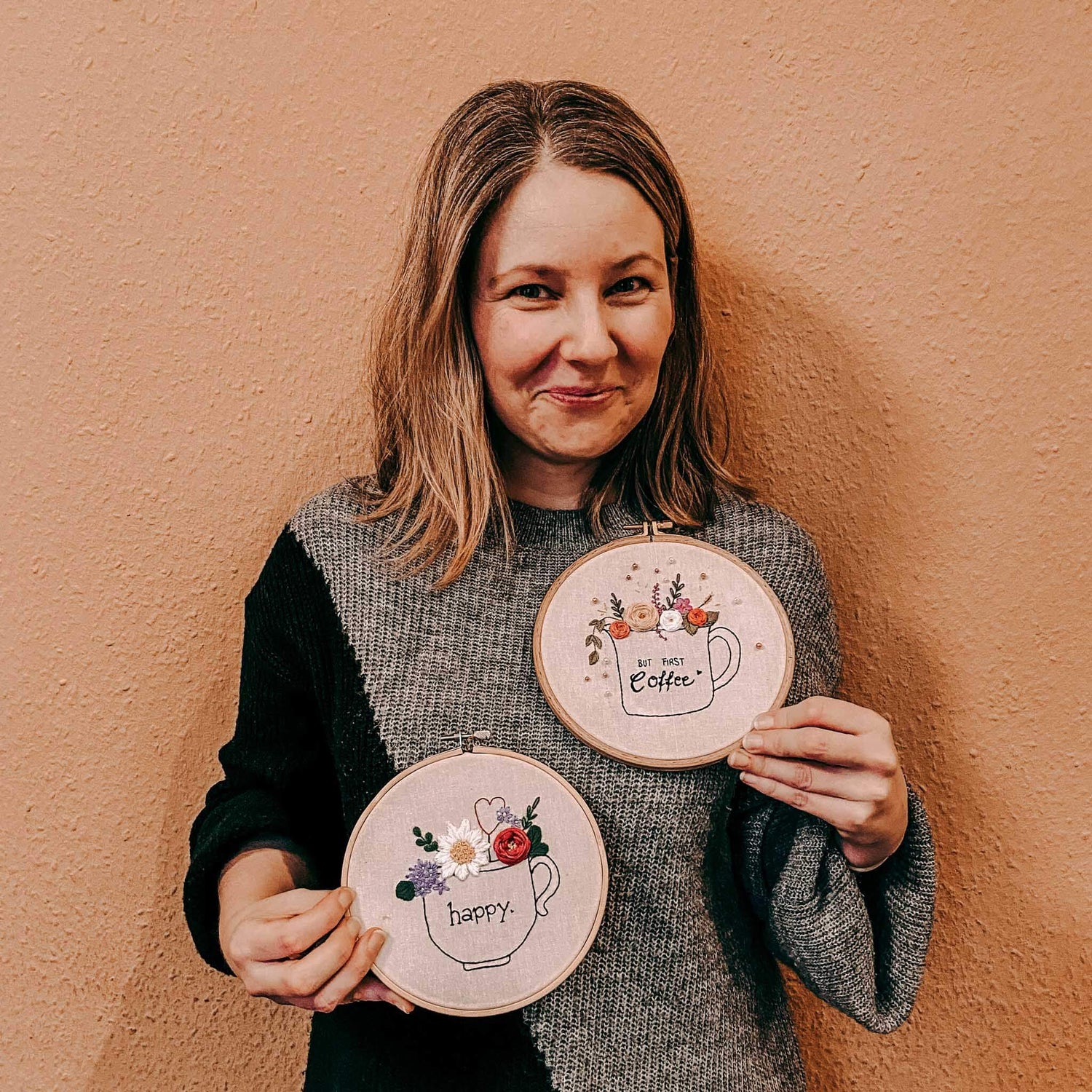 Frau hält zwei bestickte Stoffe mit Coffee Cups und Blumen, DIY Workshop bei Grimms Garten Berlin