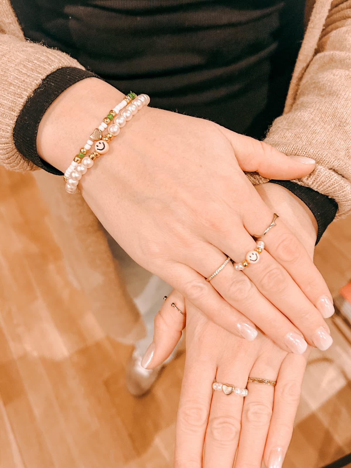 Hände mit bunten Perlenringen und Armbändern aus dem DIY Perlenschmuck Workshop von GRIMMS GARTEN, kreativer Schmuckkurs in Berlin