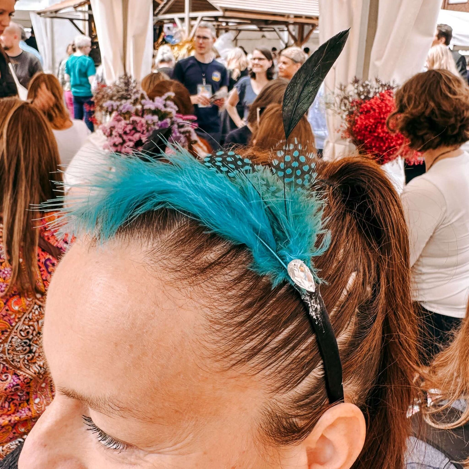 Frau trägt blauen Haarschmuck im Stil der Goldenen Zwanziger – Teamevent oder 20er Jahre Party.