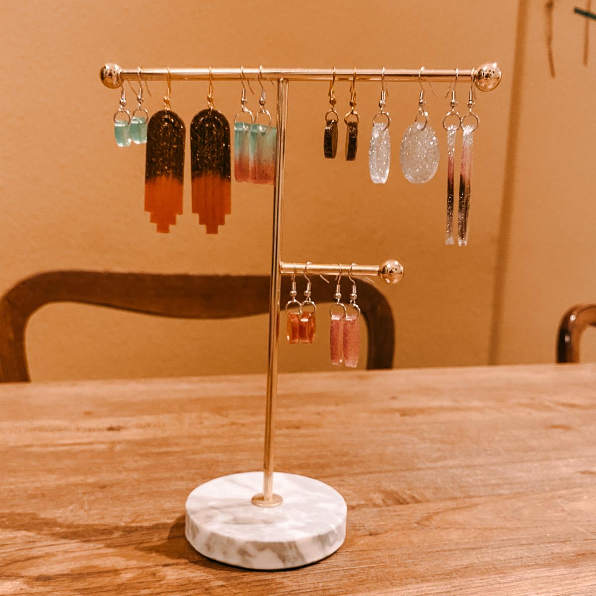 Schmuckständer mit vielen Resin Ohrringen in verschiedenen Formen – kreativer Resin Schmuckkurs.