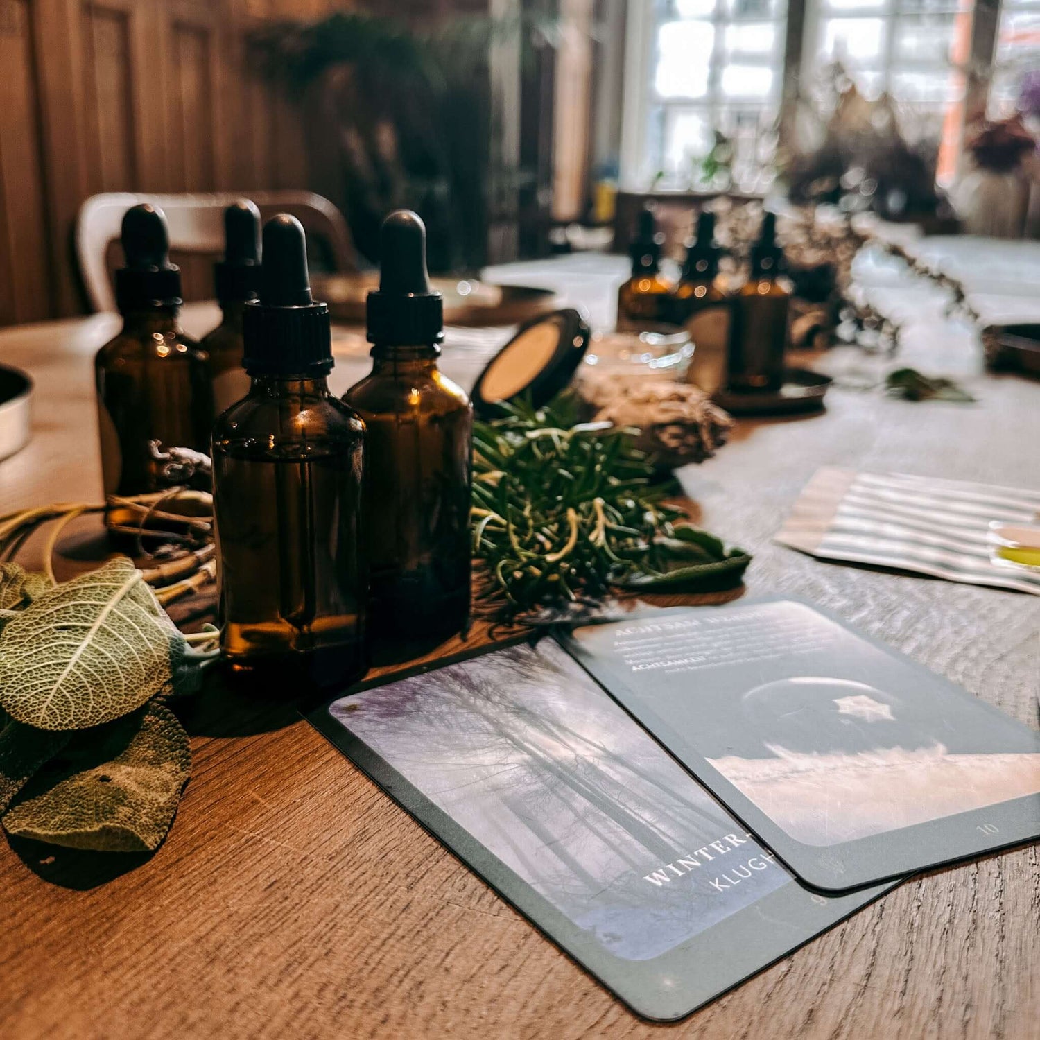 Mehrere kleine Fläschchen mit Deko und mystischen Karten auf Tisch – rauhnacht ritual, spiritual workshop berlin, ätherische öle.
