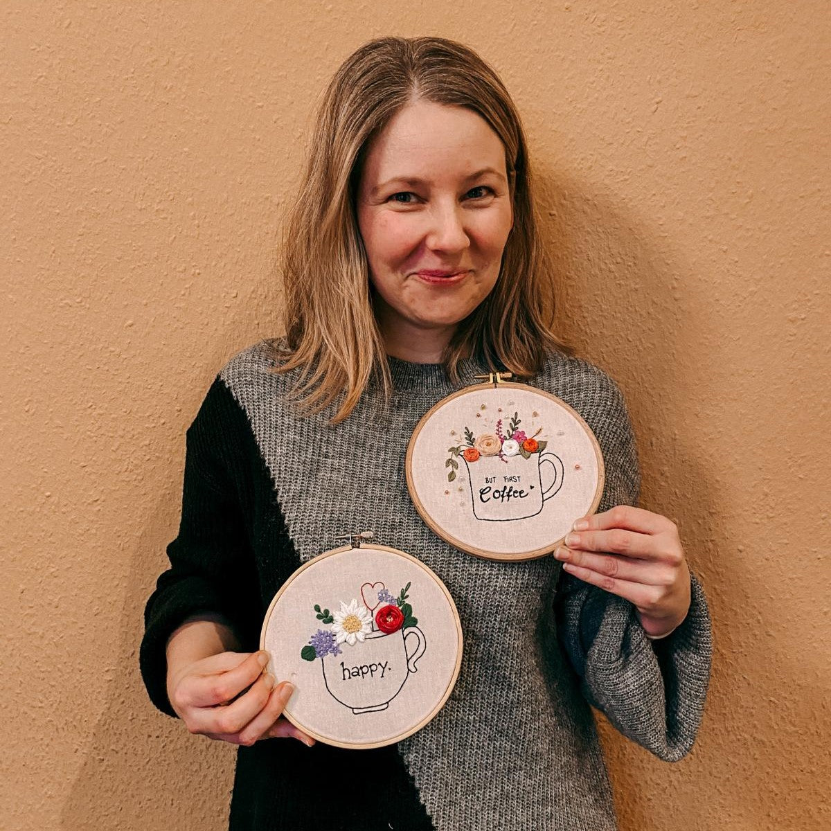 Zwei gestickte Tassen mit Blumen, Person hält sie in Händen – stickerei kunst, embroidery workshop, kreative handarbeit.