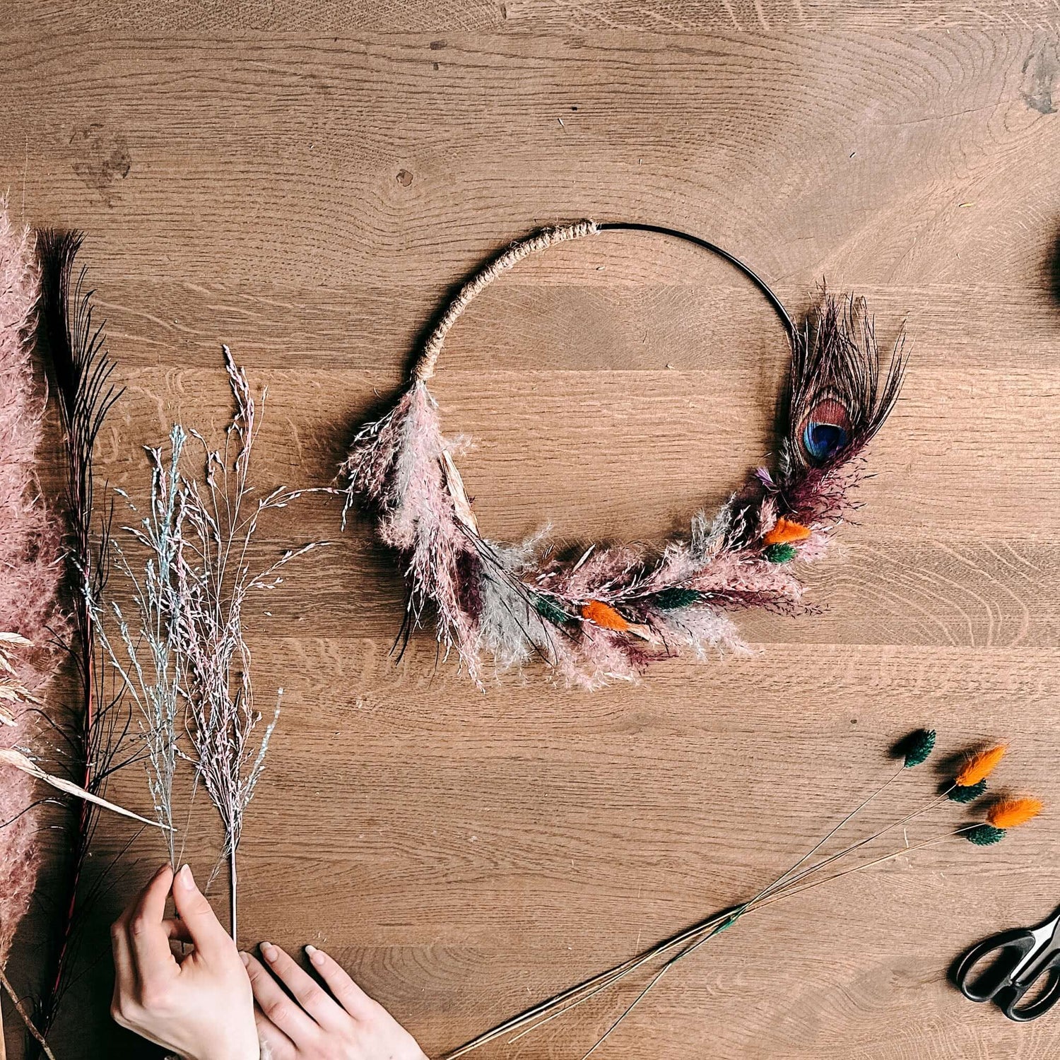 Zwei Hände gestalten Trockenblumenring Pfauenauge – kreatives DIY Erlebnis für JGA oder Deko.