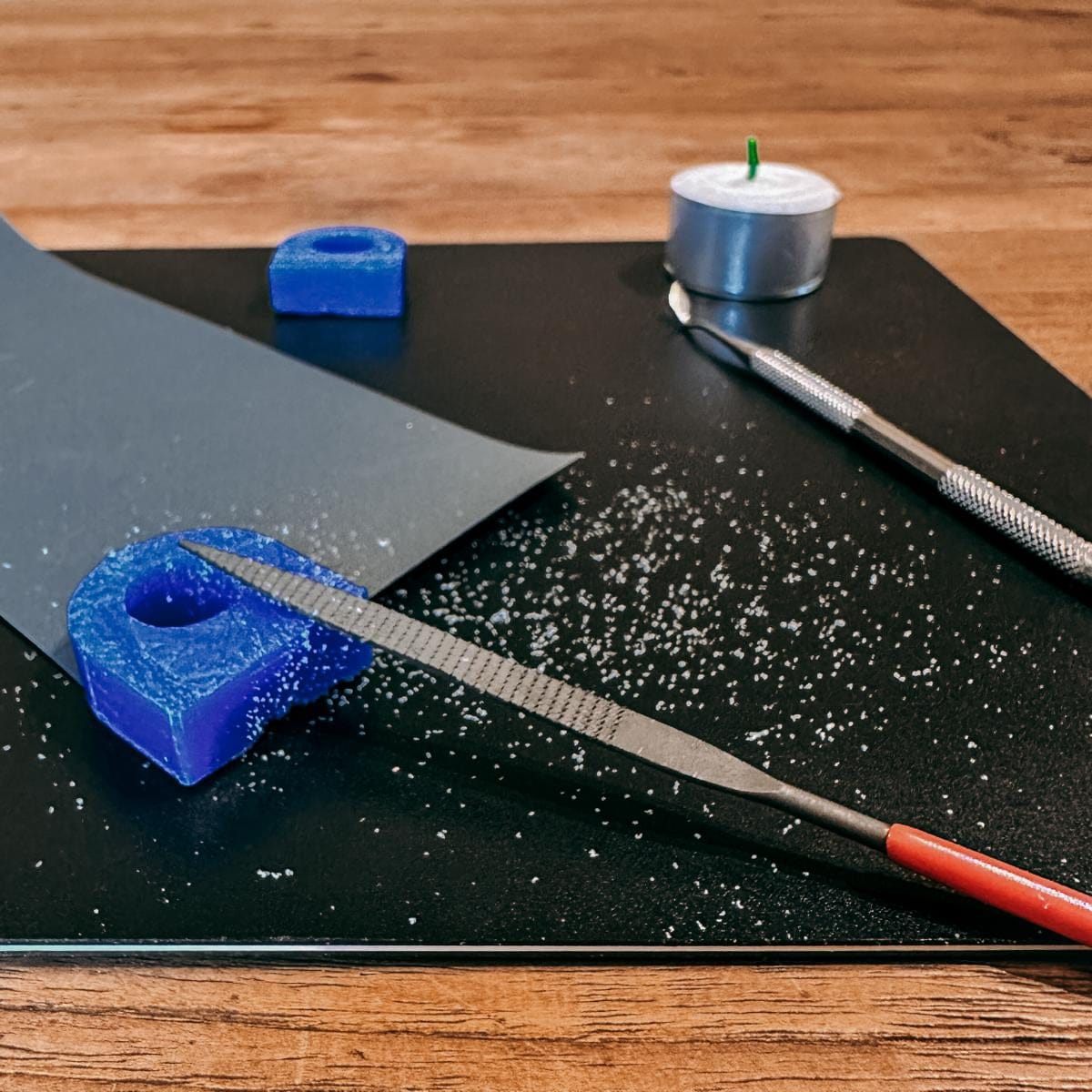 Schwarze Matte mit blauer Wachsform und Werkzeug – Wachsring modellieren leicht gemacht.