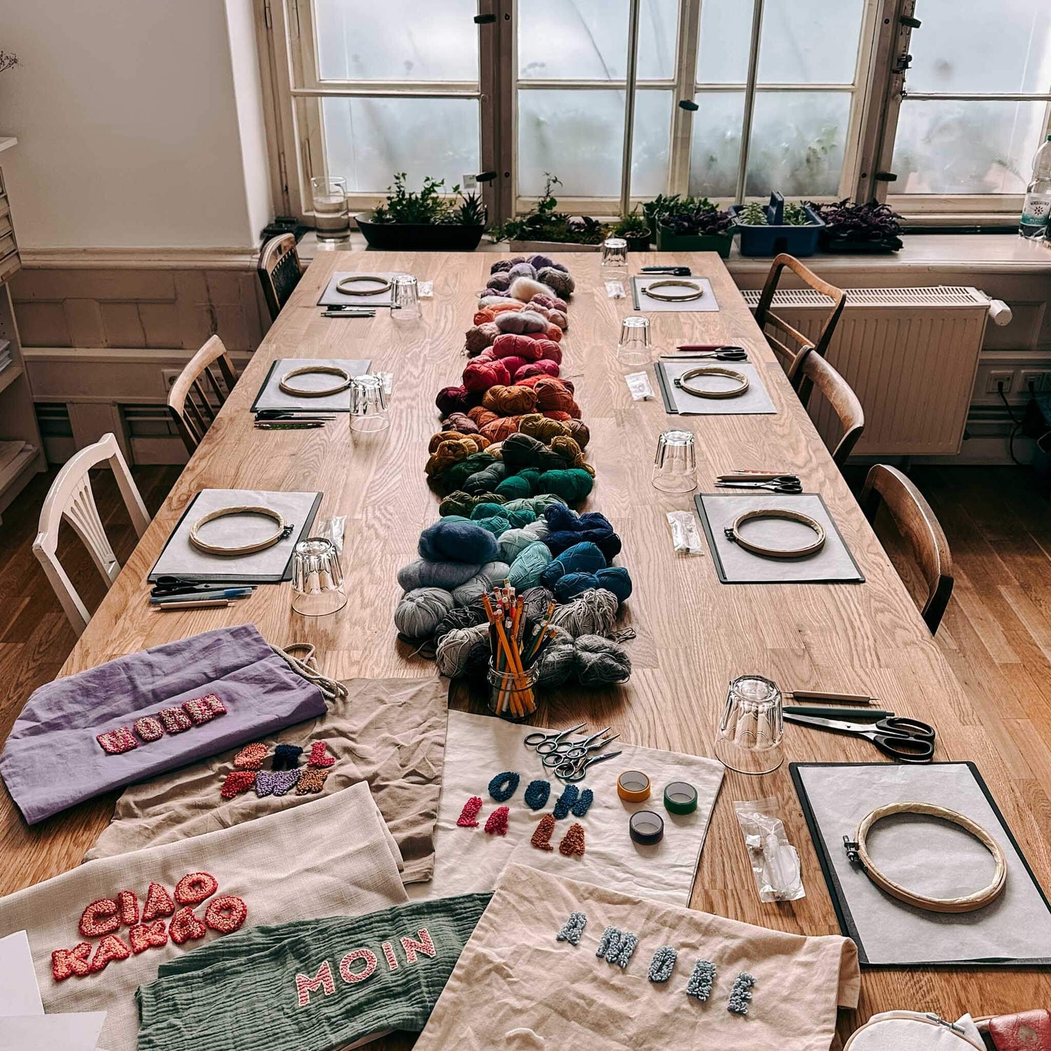 Tisch mit Materialien, Wolle und fertigen Stoffen – DIY Punch-Needle Workshop Berlin.