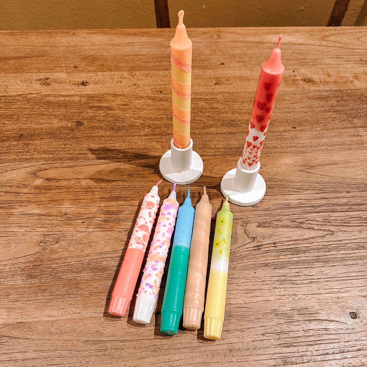 Bunte Dip-Dye-Kerzen auf Tisch, zwei gelb-rote Kerzen im Kerzenständer, DIY Workshop bei Grimms Garten Berlin