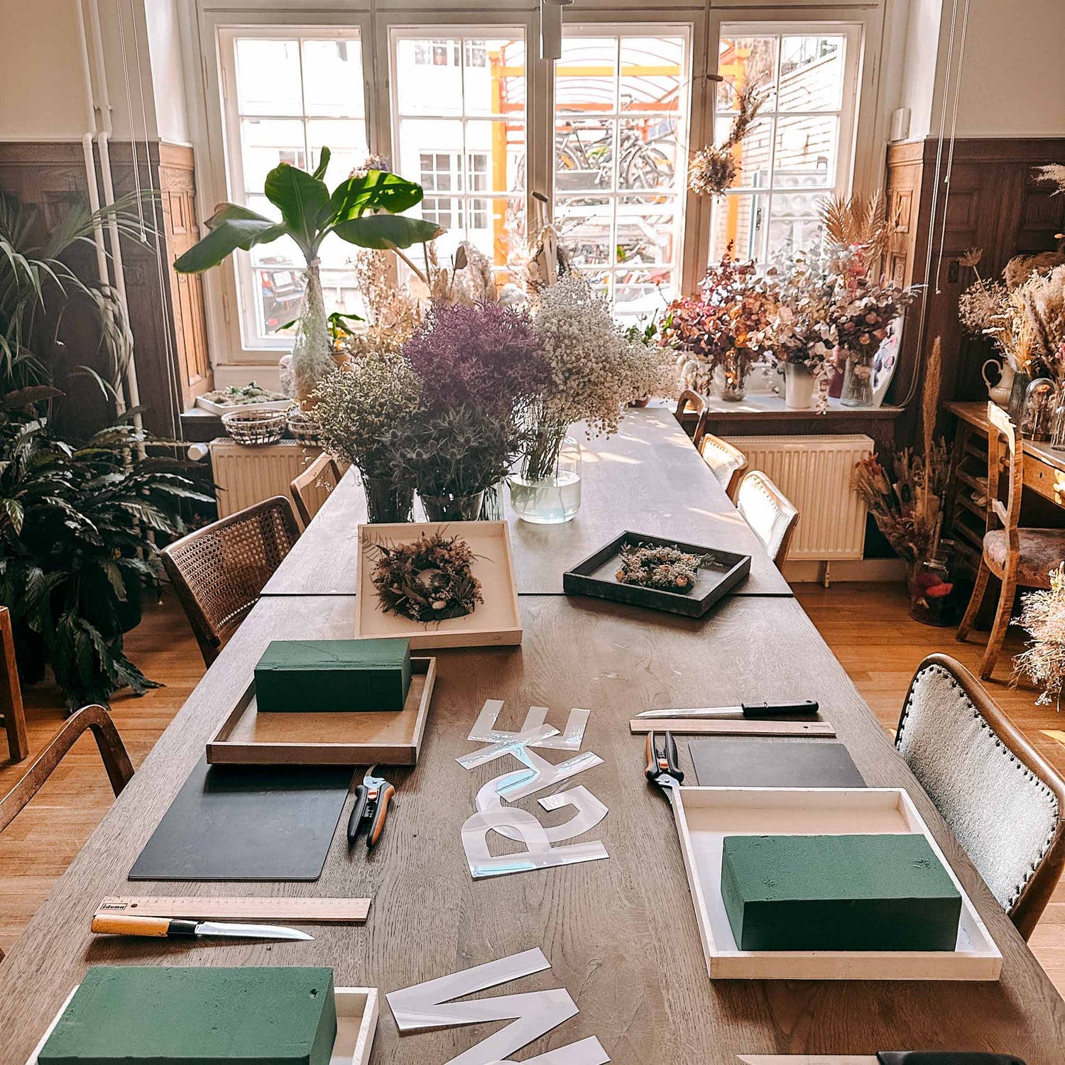 Arbeitstisch mit Blumen, Werkzeugen und Materialien – flower monogramm workshop, diy blumenletter.