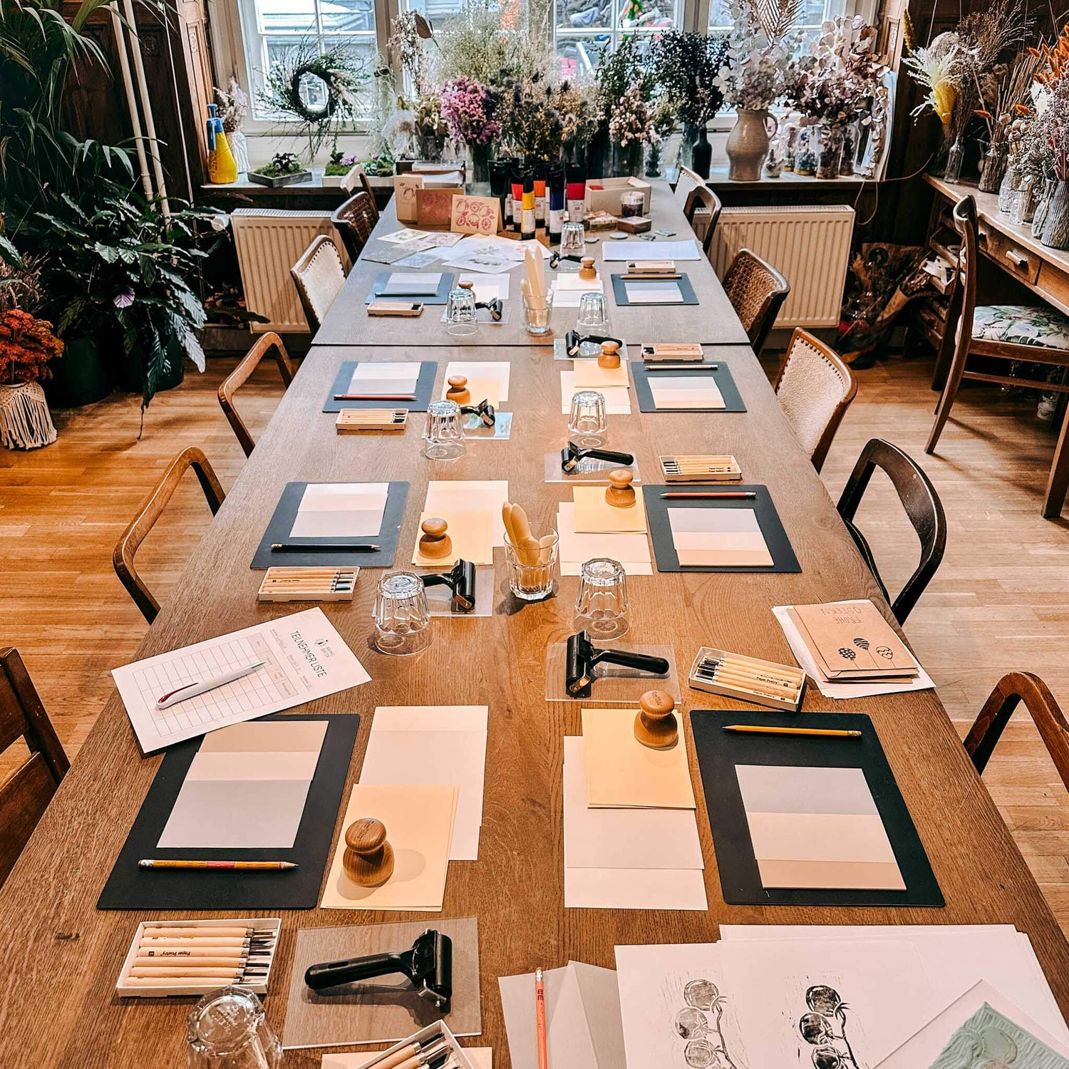Tisch mit vorbereiteten Arbeitsplätzen und Materialien für Workshop – Linolschnitt, Linoldruck, DIY Workshop.