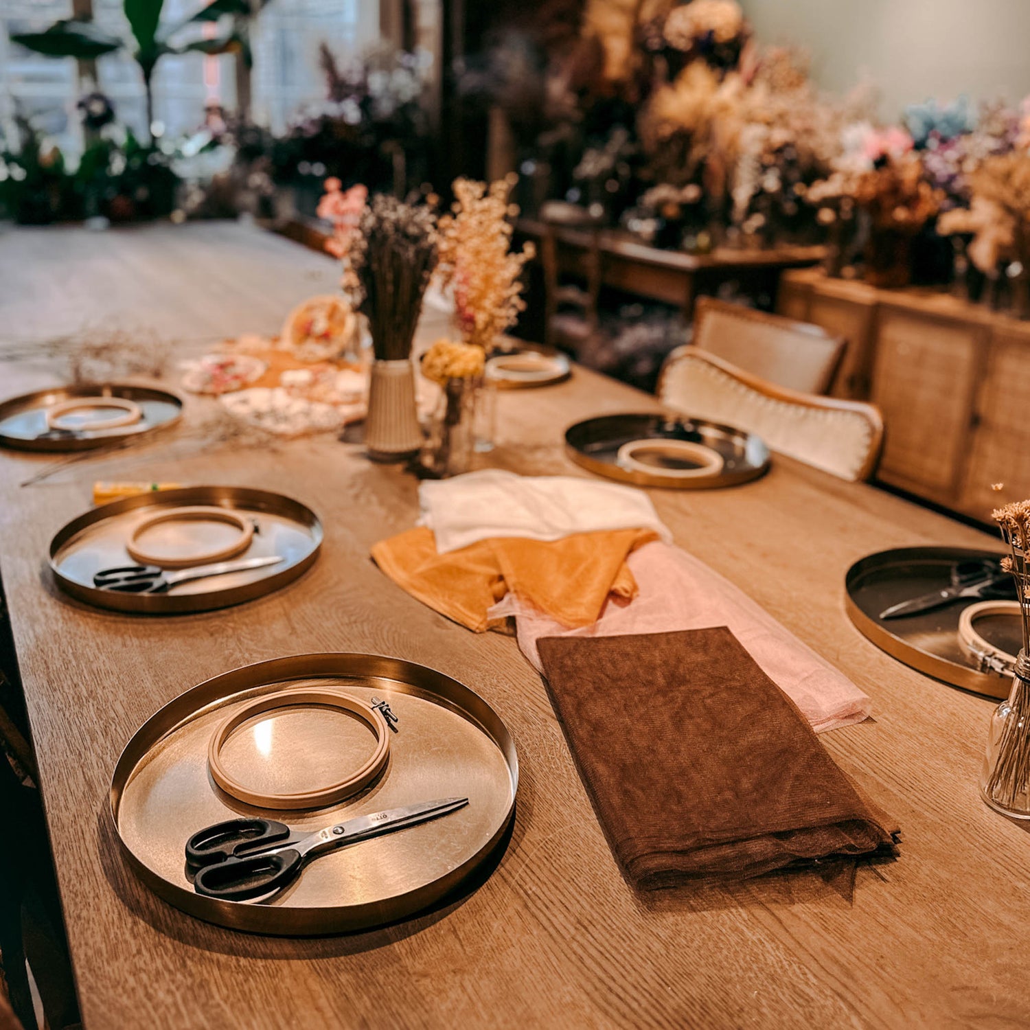 Sechs fertige Arbeitsplätze mit goldenem Tablett, Scheren und Materialien – DIY Blumenbild Workshop, Trockenblumen
