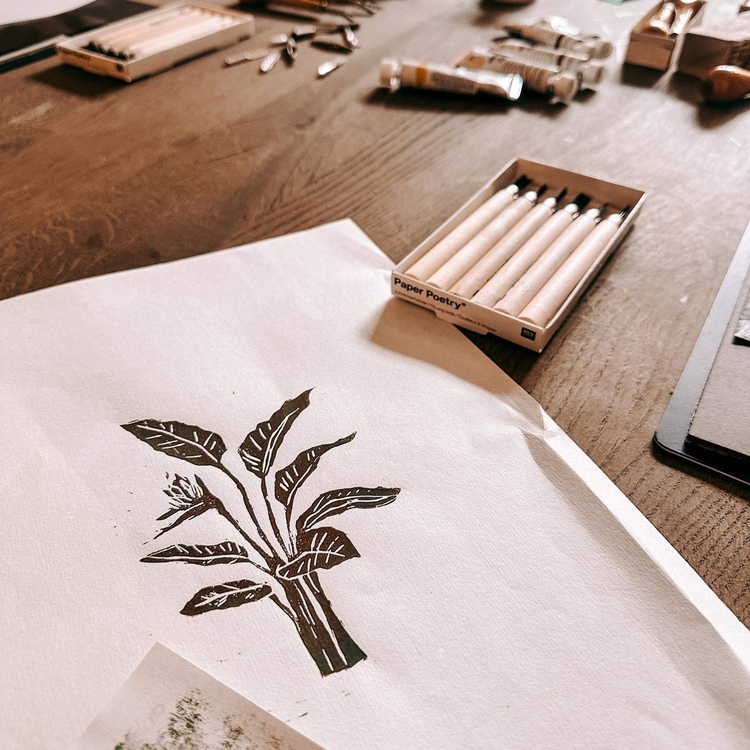 Alle Materialien auf Holztisch zusammen – Linolschnitt, Linoldruck, DIY Workshop.