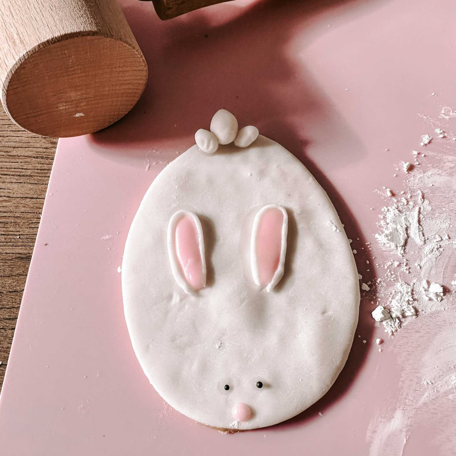 Handdekorierter Osterkeks in Hasenform auf pinker Backmatte beim Osterkekse Workshop von GRIMMS GARTEN, kreativer Backkurs in Berlin