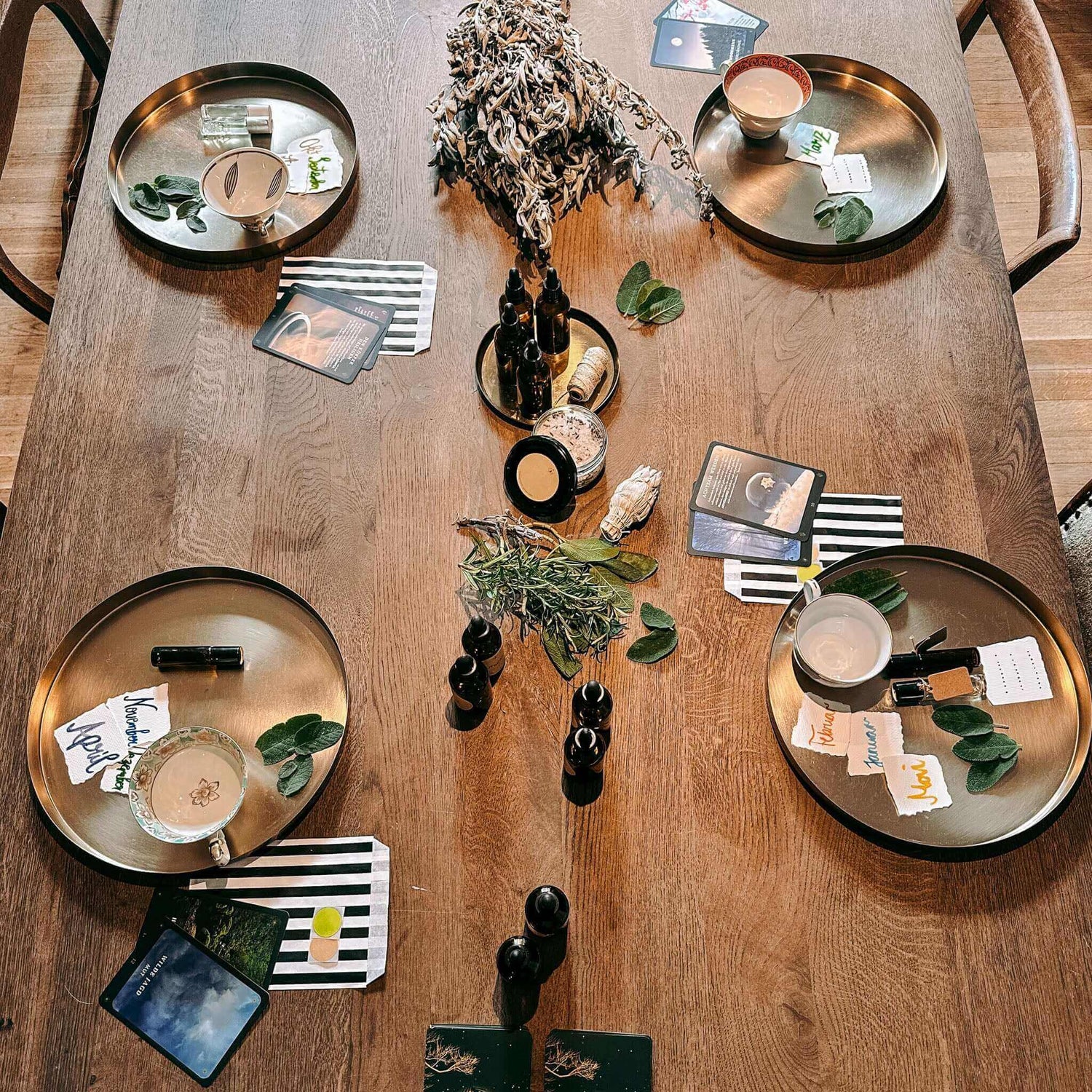 Vier Arbeitsbereiche mit Materialien und Fläschchen auf Tisch – rauhnächte workshop, diy ritualset, spiritual workshop berlin.