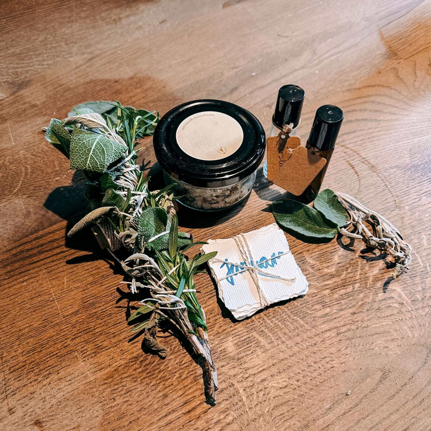 Zettel mit Kräutern, Salz und Fläschchen zusammengebunden auf Holztisch – diy ritualset, räucherkräuter, rauhnächte workshop.