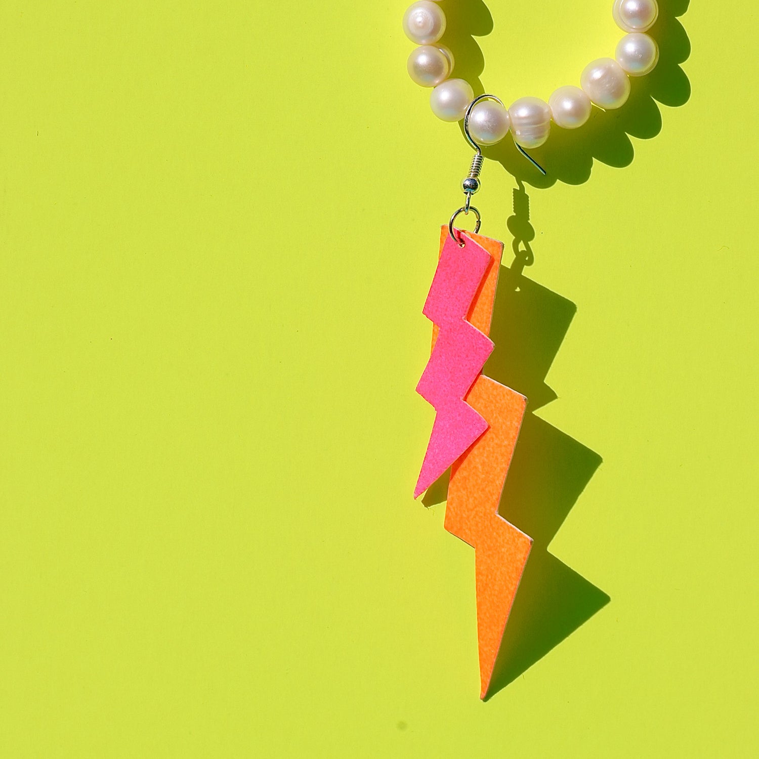 Pink-orange Blitzohrringe aus veganem Leder an Perlenkette – Boho Schmuckdesign Workshop.