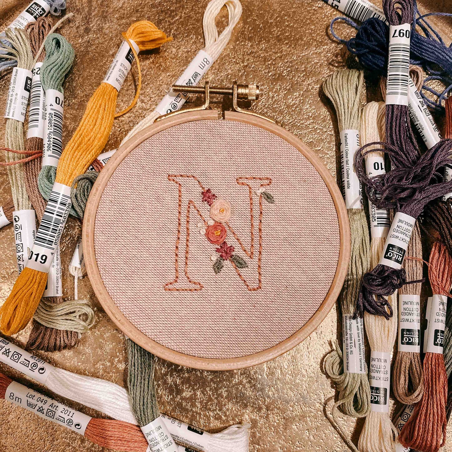 Gesticktes N mit Blumen auf Tisch und Garn – Stickkurs für Anfänger, kreative Handarbeit