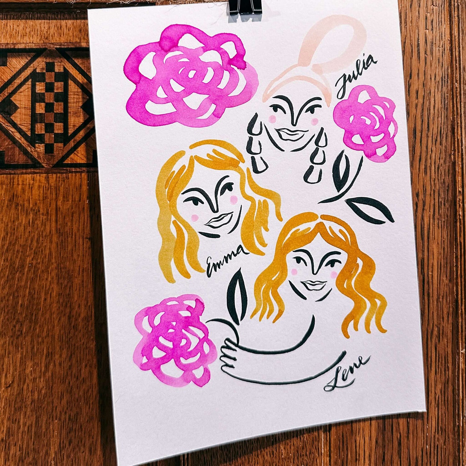 Fertiges Aquarell-Portrait mit drei Gesichtern, Blumen und Namen – kreatives Teamevent Highlight.