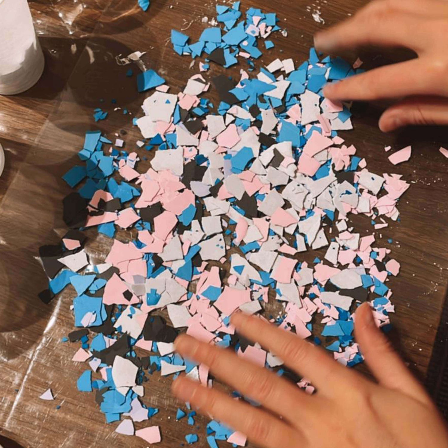 Hand ordnet farbige Chips auf Tisch – DIY Deko Idee beim Terrazzo Workshop Berlin.