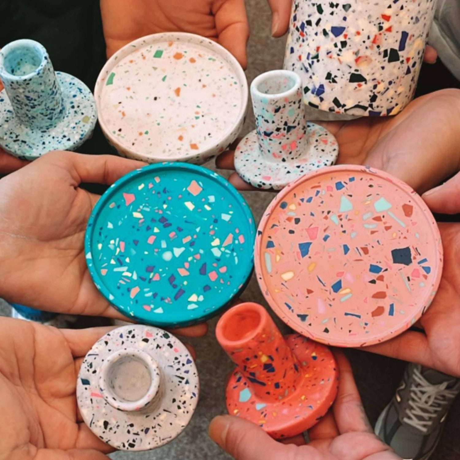 Hände halten bunte Terrazzo-Kerzenständer – Terrazzo Workshop Berlin für kreative Team Events.