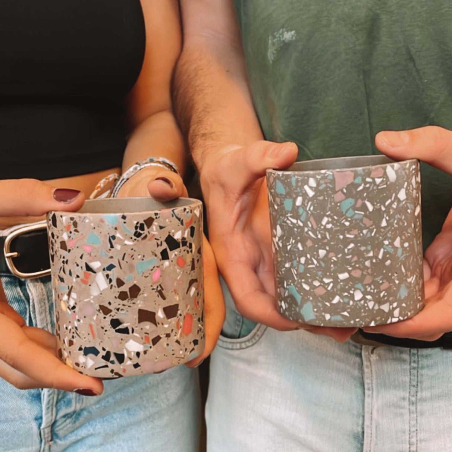 Zwei Personen halten graue Pflanztöpfe – kreativer Team Event im Terrazzo Workshop Berlin.