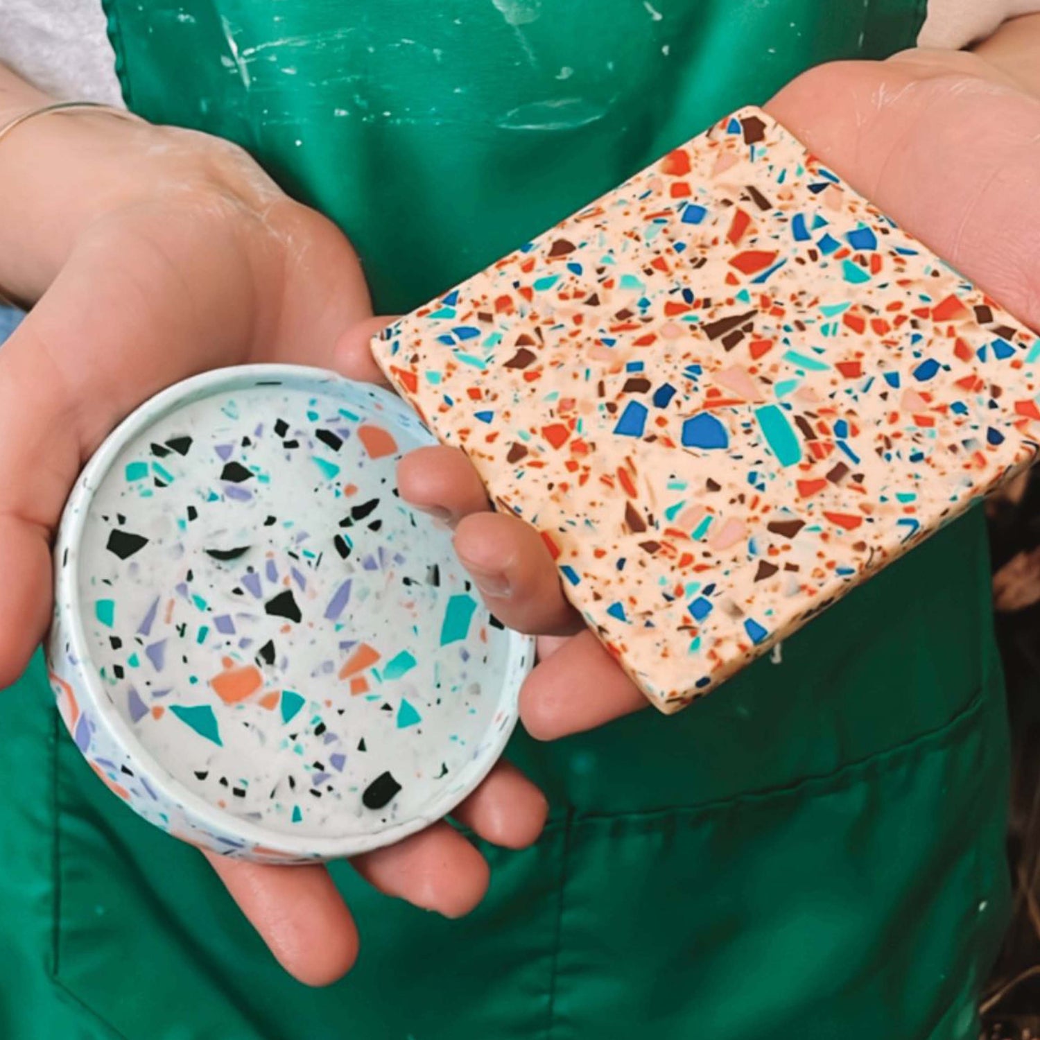 Person hält zwei Untersetzer in Blau und Orange – individuelle DIY Deko Berlin Workshop.