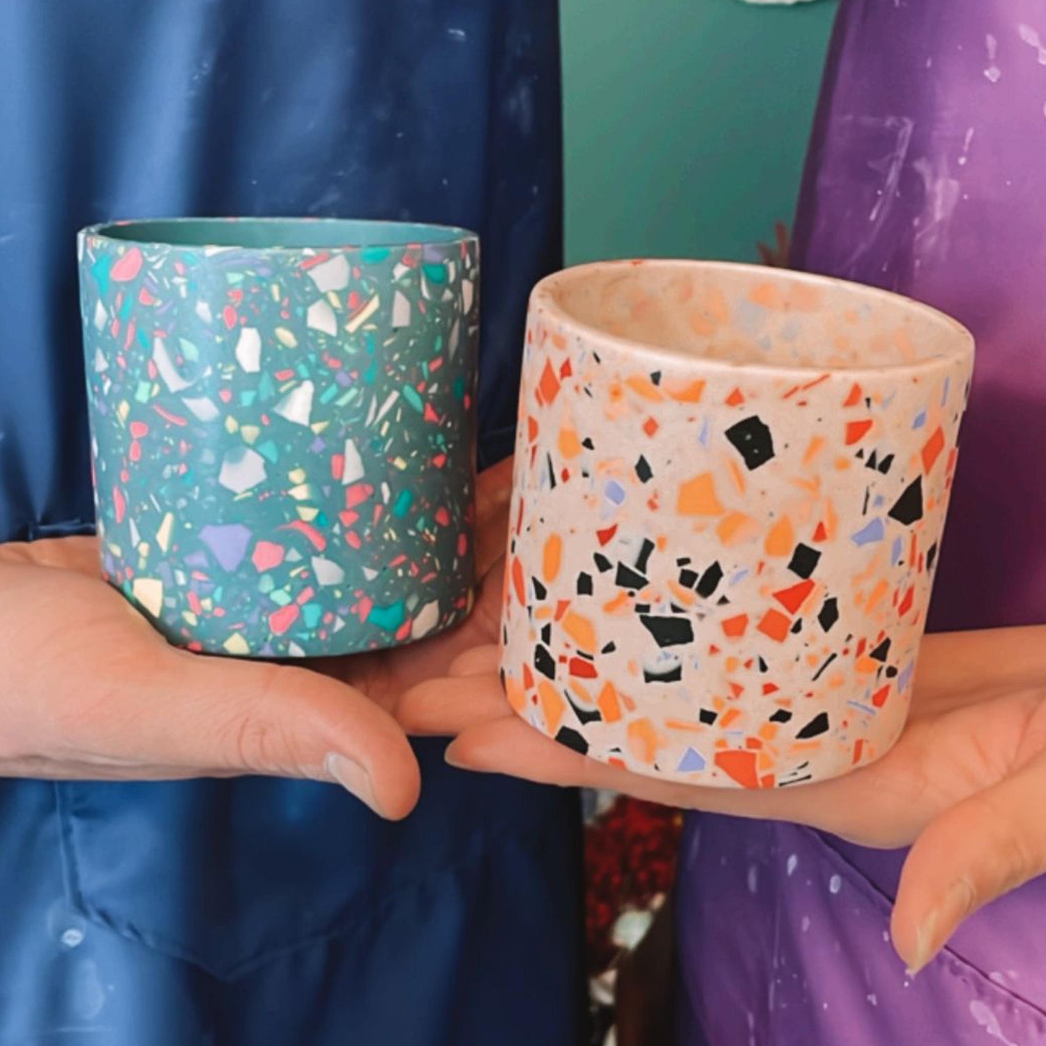 Zwei Personen mit Terrazzo-Pflanztöpfen in Grün und Pink – Design Workshop für Teams Berlin.