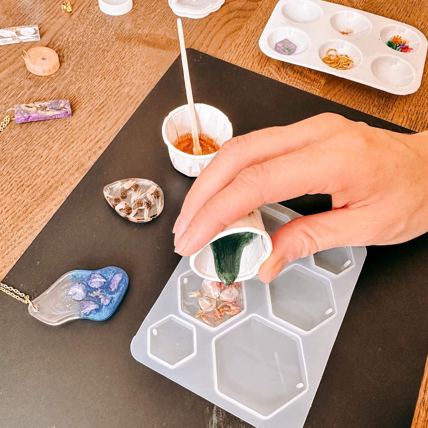 Harz wird in Formen gegossen, Materialien auf Tisch – resin workshop, uv harz schmuck, auch für Firmenevents.