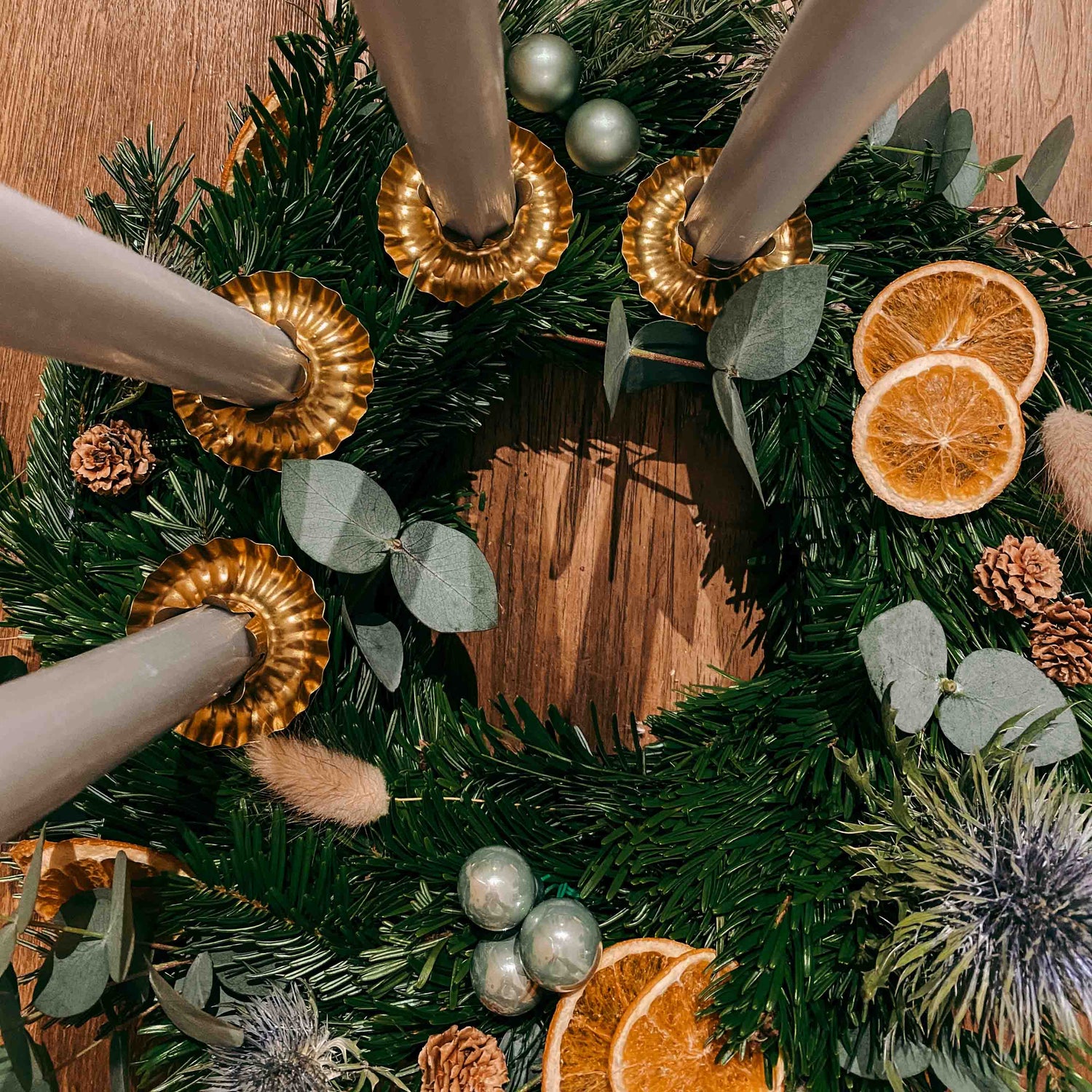 Kranz mit grauen Kerzen und grünen, blauen Elementen – stilvolle Weihnachtsidee Sterntaler.